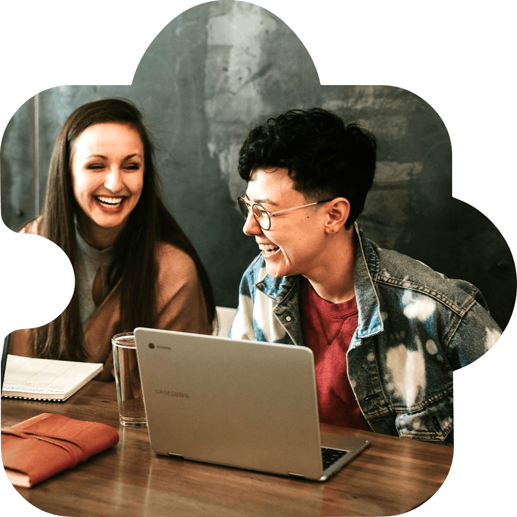 students learning and laughing near laptop 