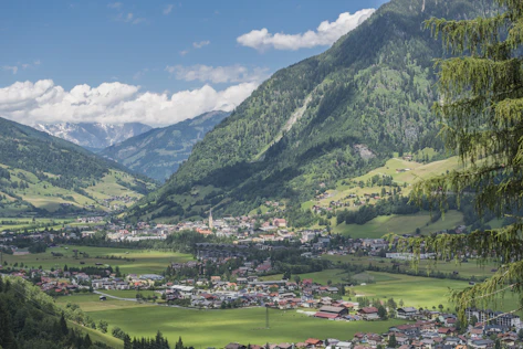 Panoramablick über Bad Hofgastein mit weitläufigen Grünflächen, Alpenkulisse und hochwertiger Wohnlage – präsentiert von Simon Immobilien.
