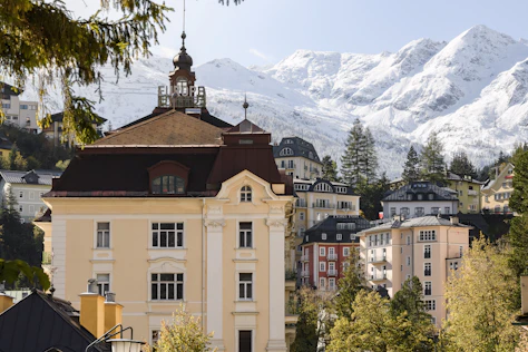 Historische Architektur in Bad Gastein vor schneebedeckter Alpenkulisse – eindrucksvolle Wohn- und Lebensqualität, präsentiert von Simon Immobilien.