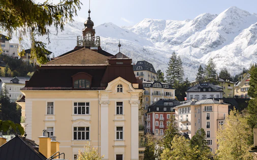 Historische Architektur in Bad Gastein vor schneebedeckter Alpenkulisse – eindrucksvolle Wohn- und Lebensqualität, präsentiert von Simon Immobilien.