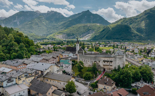 Blick auf den Ort Forstau mit Häusern und Kirche im Tal, umgeben von grünen Wiesen und Bergen der Salzburger Alpen.