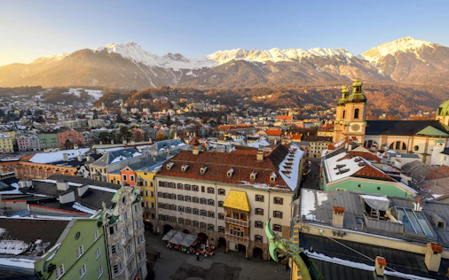 Panoramablick über die Stadt Bischofshofen mit Kirche, Wohnhäusern und Bergen der Salzburger Alpen im Hintergrund.