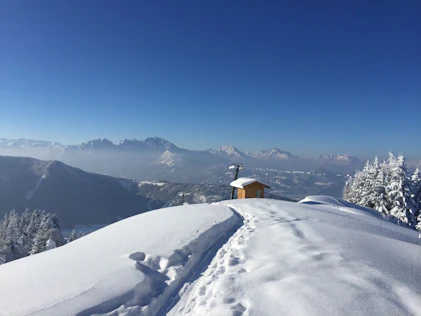 Snow-covered mountain landscape with sweeping views of the Alps, clear skies, and a sense of untouched tranquility – a place of calm and breathtaking openness.