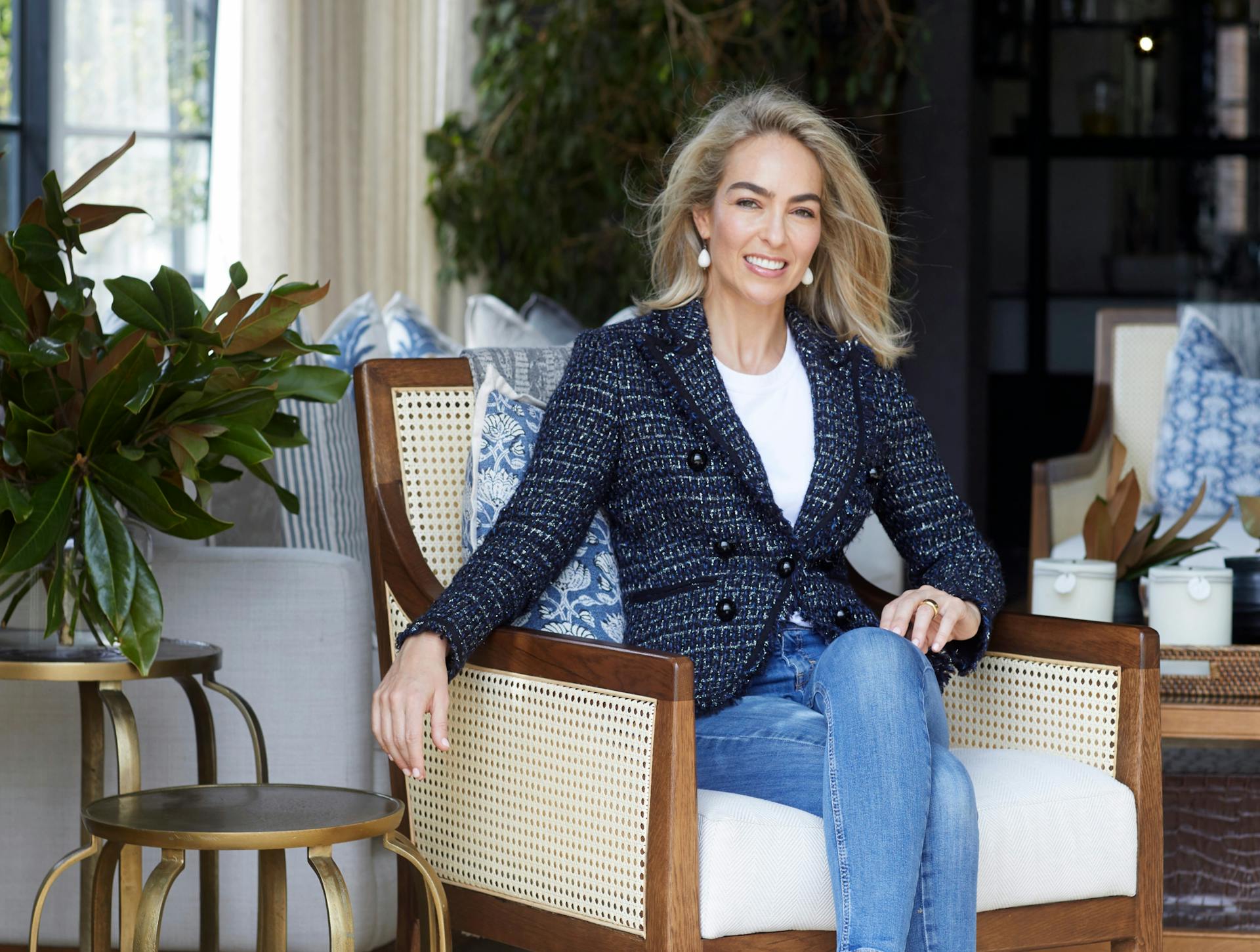 Simone Katherine sitting on a wooden chair alongside two side tables.