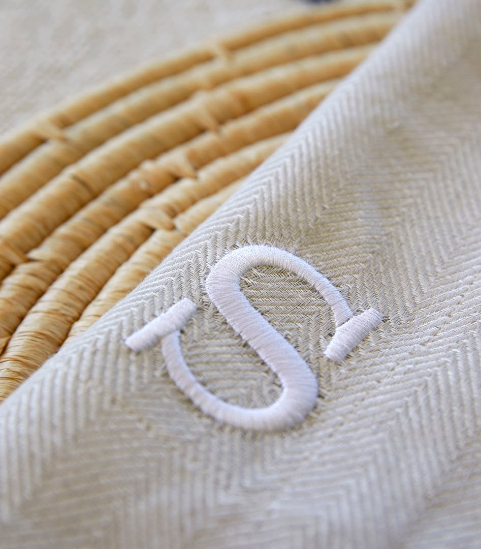 Close-up of embroidery details on fabric in the shape of an 'S'.