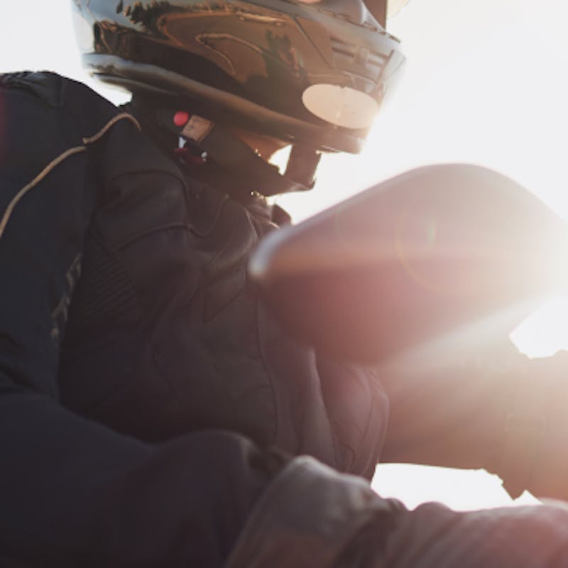 homem com capacete dirigindo uma moto