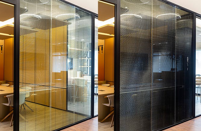, as divisórias alto padrão delimitam a sala através de paredes em vidro duplo com persiana e painel duplo