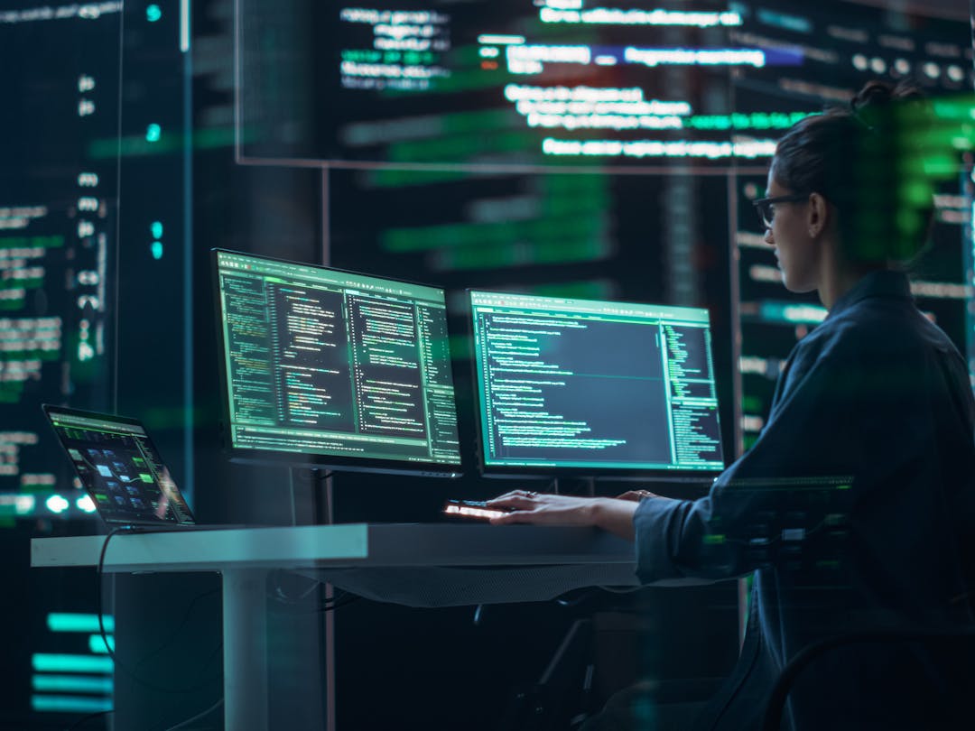 Female cyber security employee working at a computer terminal in a data center