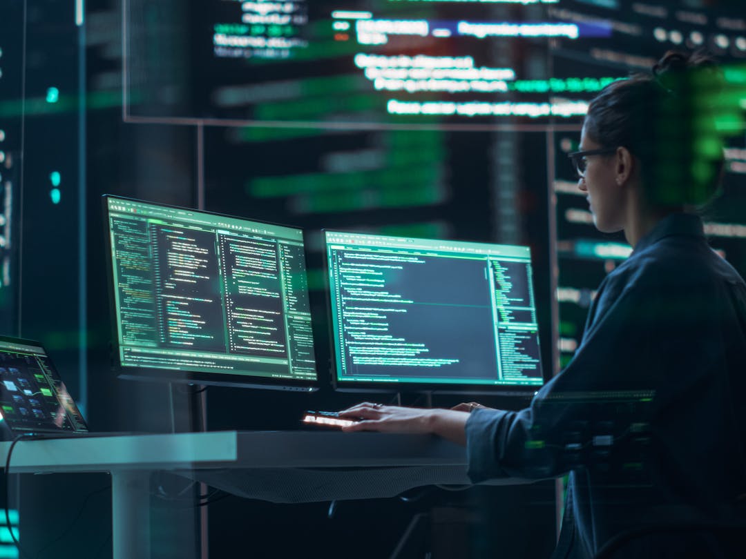 Female cyber security employee working at a computer terminal in a data center