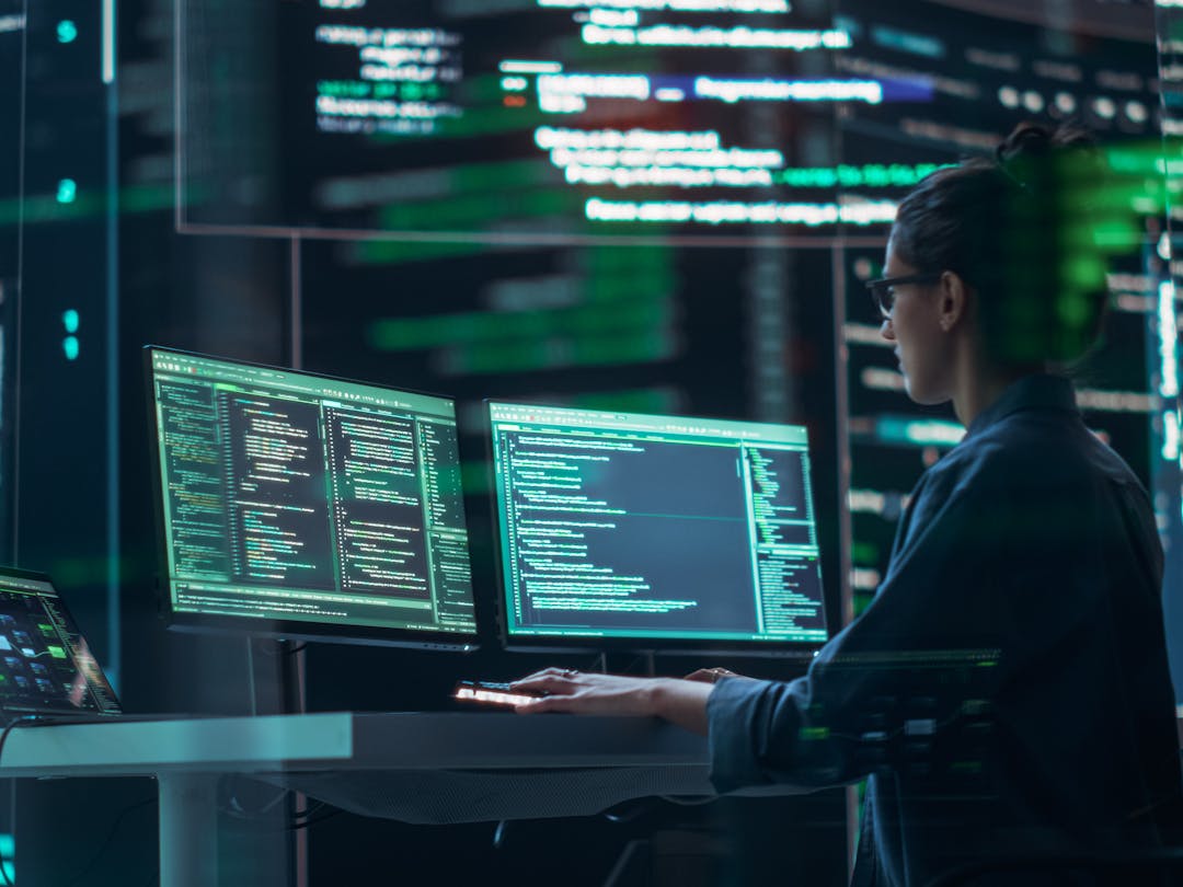 Female cyber security employee working at a computer terminal in a data center