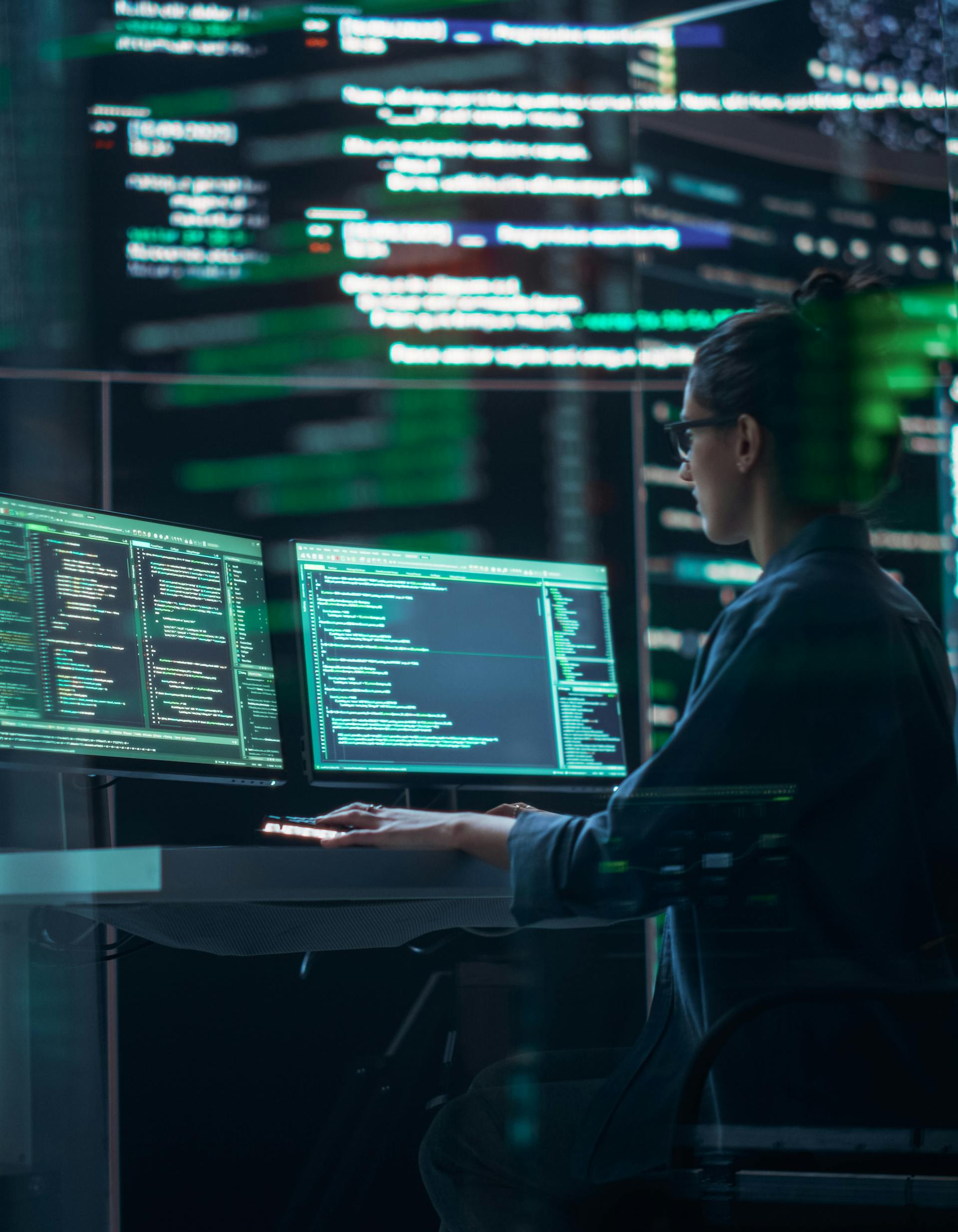 Female cyber security employee working at a computer terminal in a data center