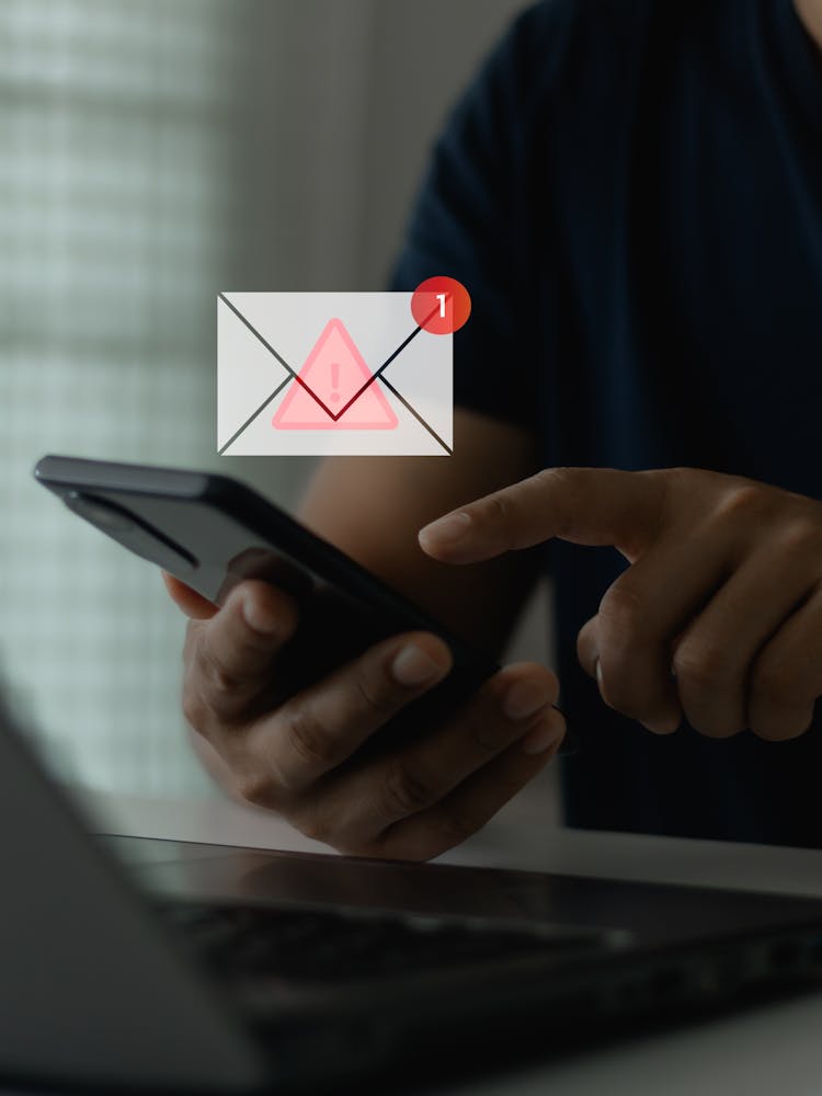 Person interacting with computer and phone receiving a dangerous email