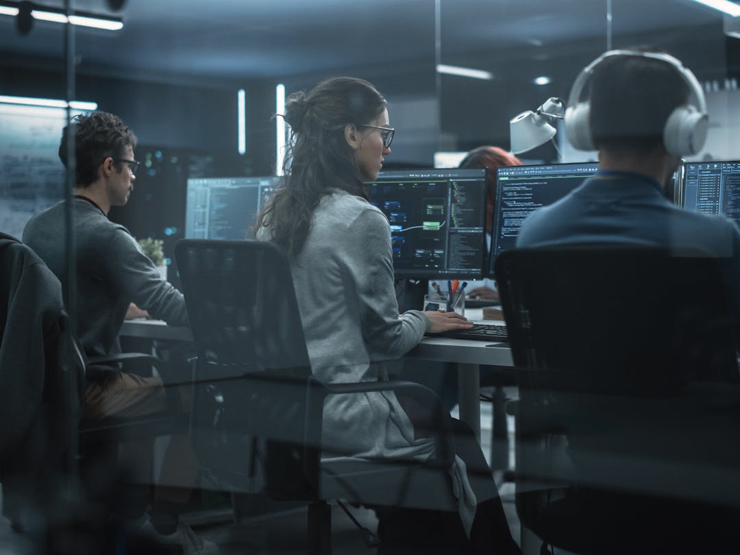 Team of cyber security professionals working at their computers