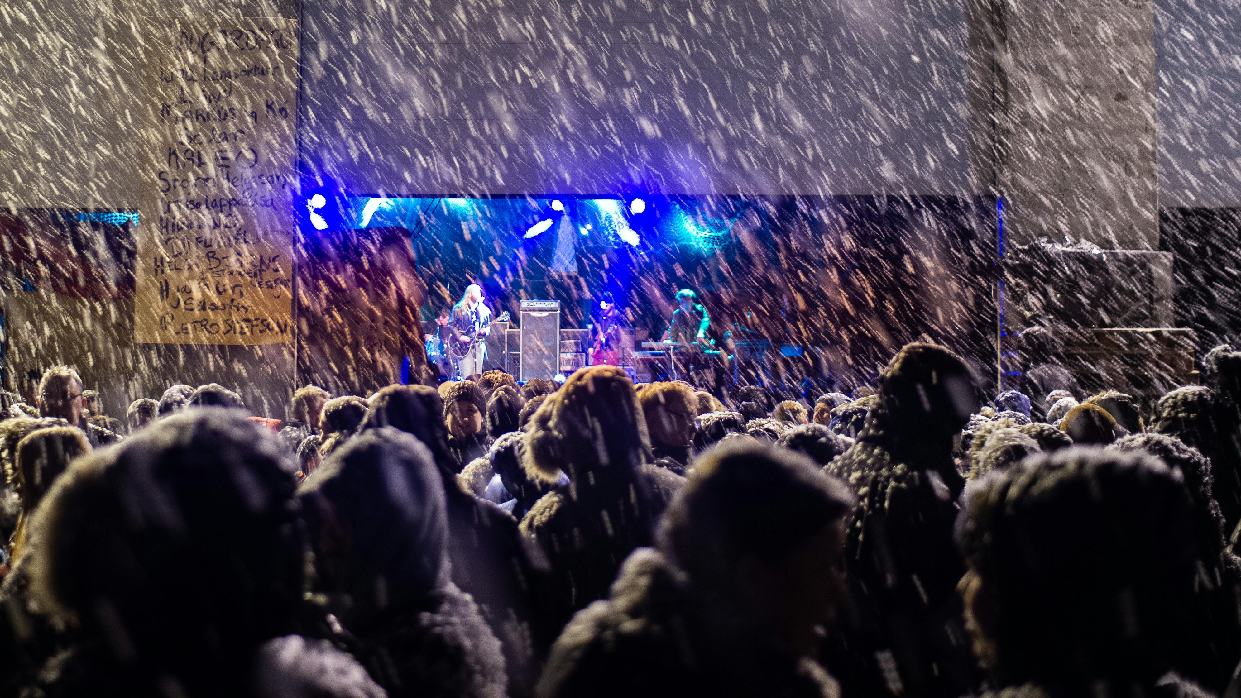 Spectators standing in the rain, watching concerts on the Aldrei festival