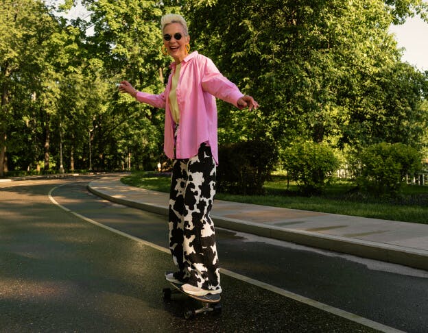 femme de 60 ans qui donne des cours de skateboard
