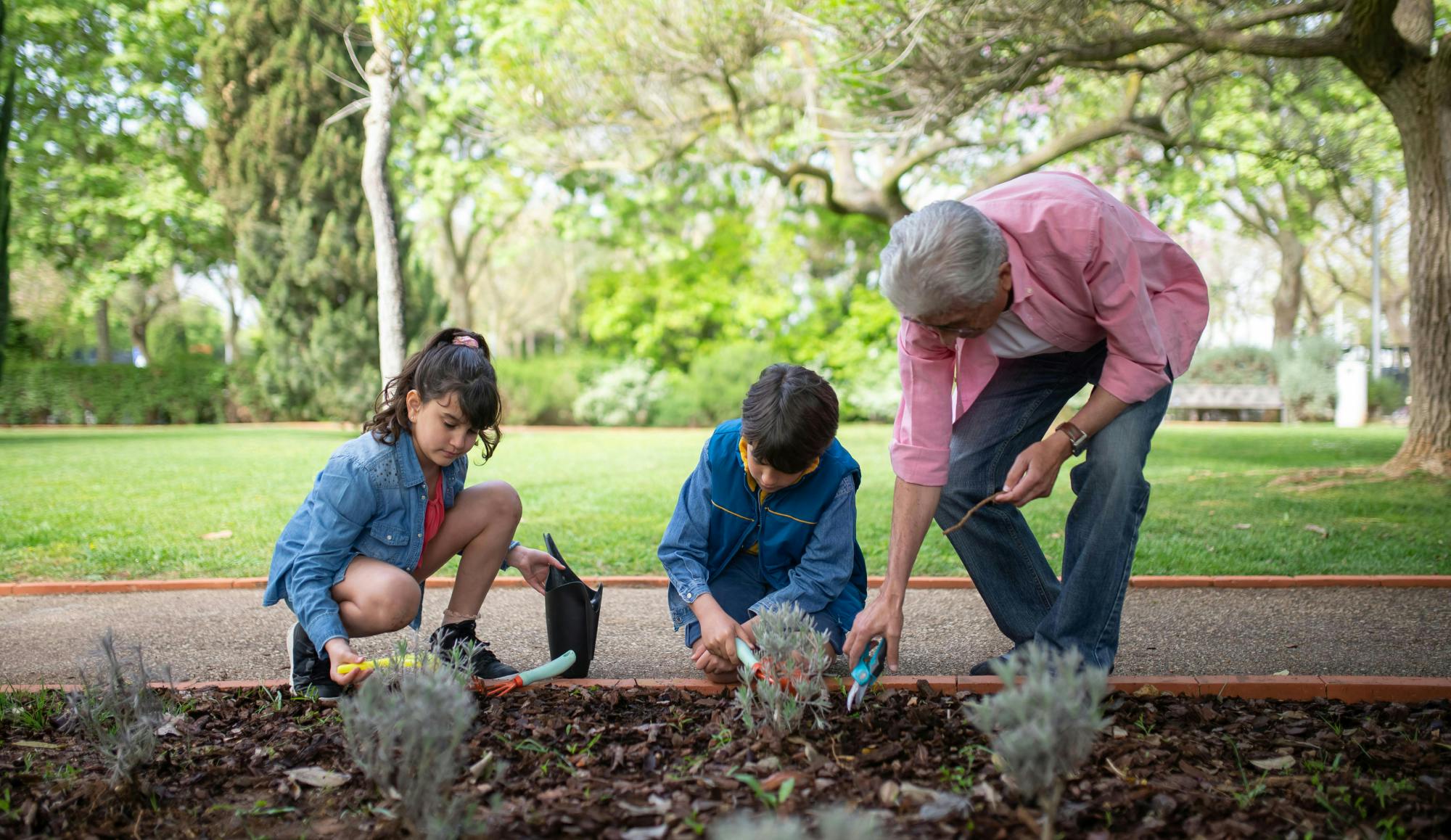 grand-père jardinant avec ses petits-enfants