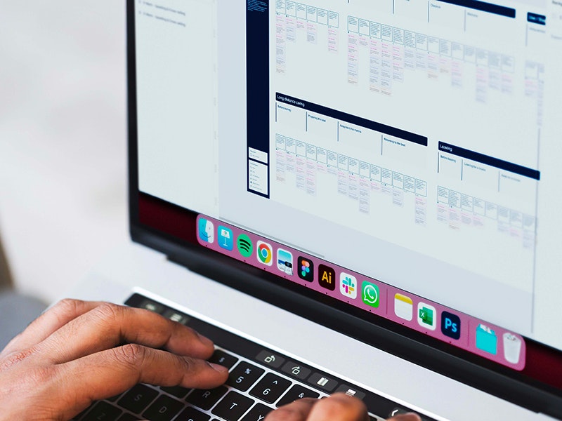 Sketchin Services, Strategy and business design - Primo piano di mani che digitano su un laptop con una blueprint sullo schermo.