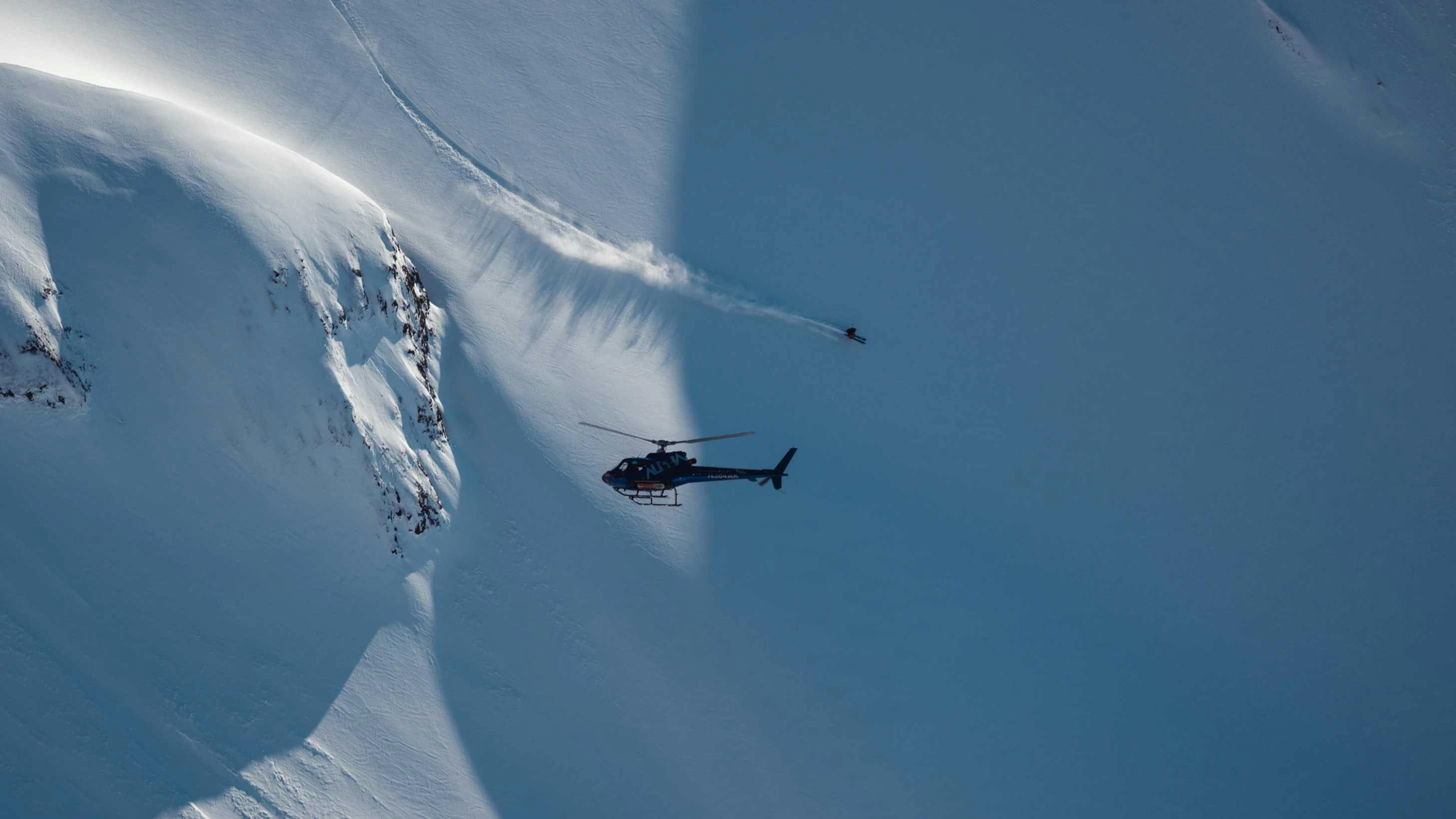 A Crown Mountain Guides helicopter transporting skiers to the summit.