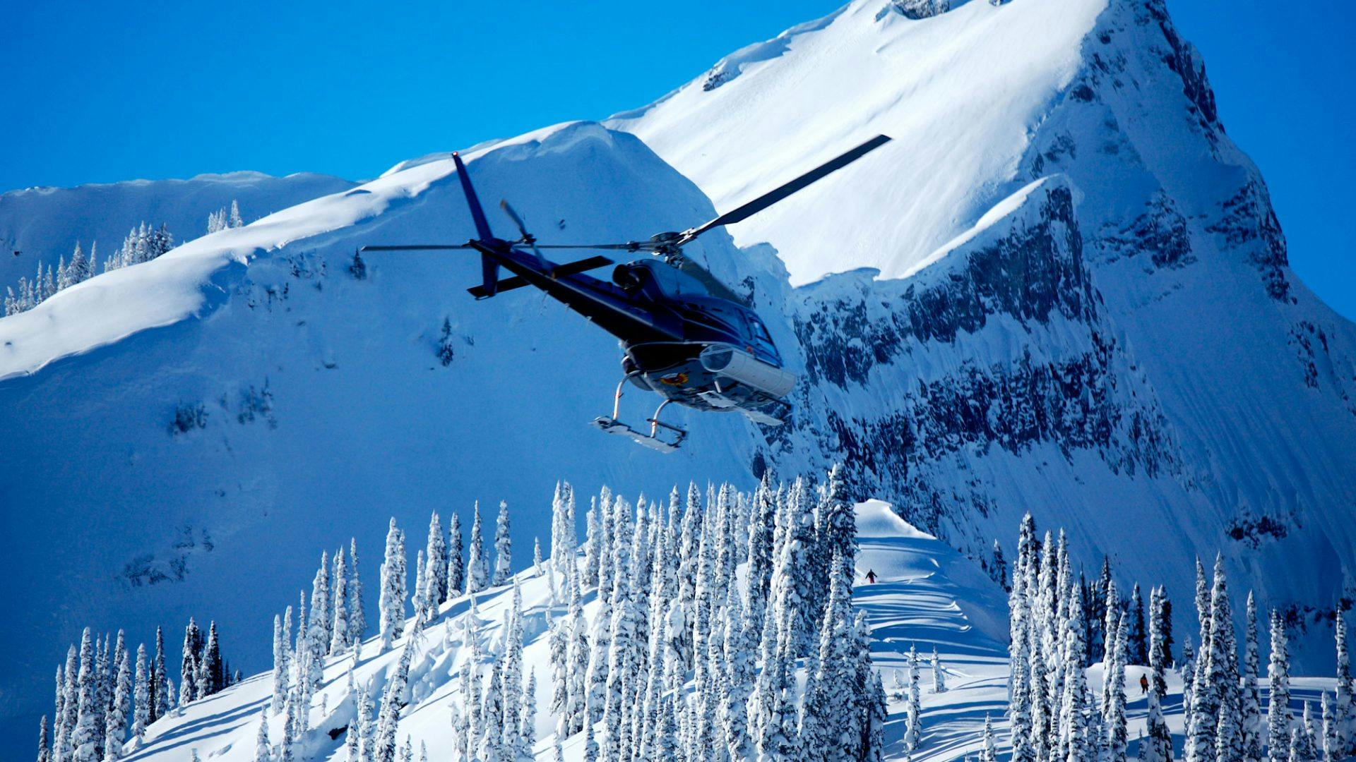 A helicopter flying over the slopes of Revelstoke in British Columbia, Canada.