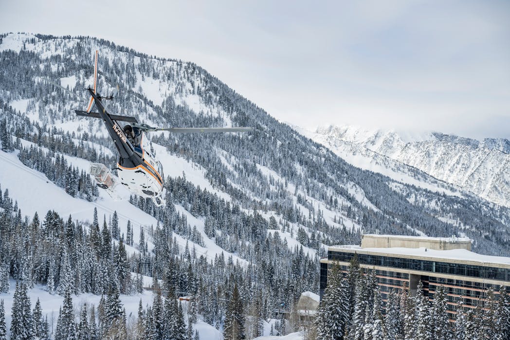 A Utah Powder Birds helicopter zipping past Snowbird Ski Resort in Utah, United States.