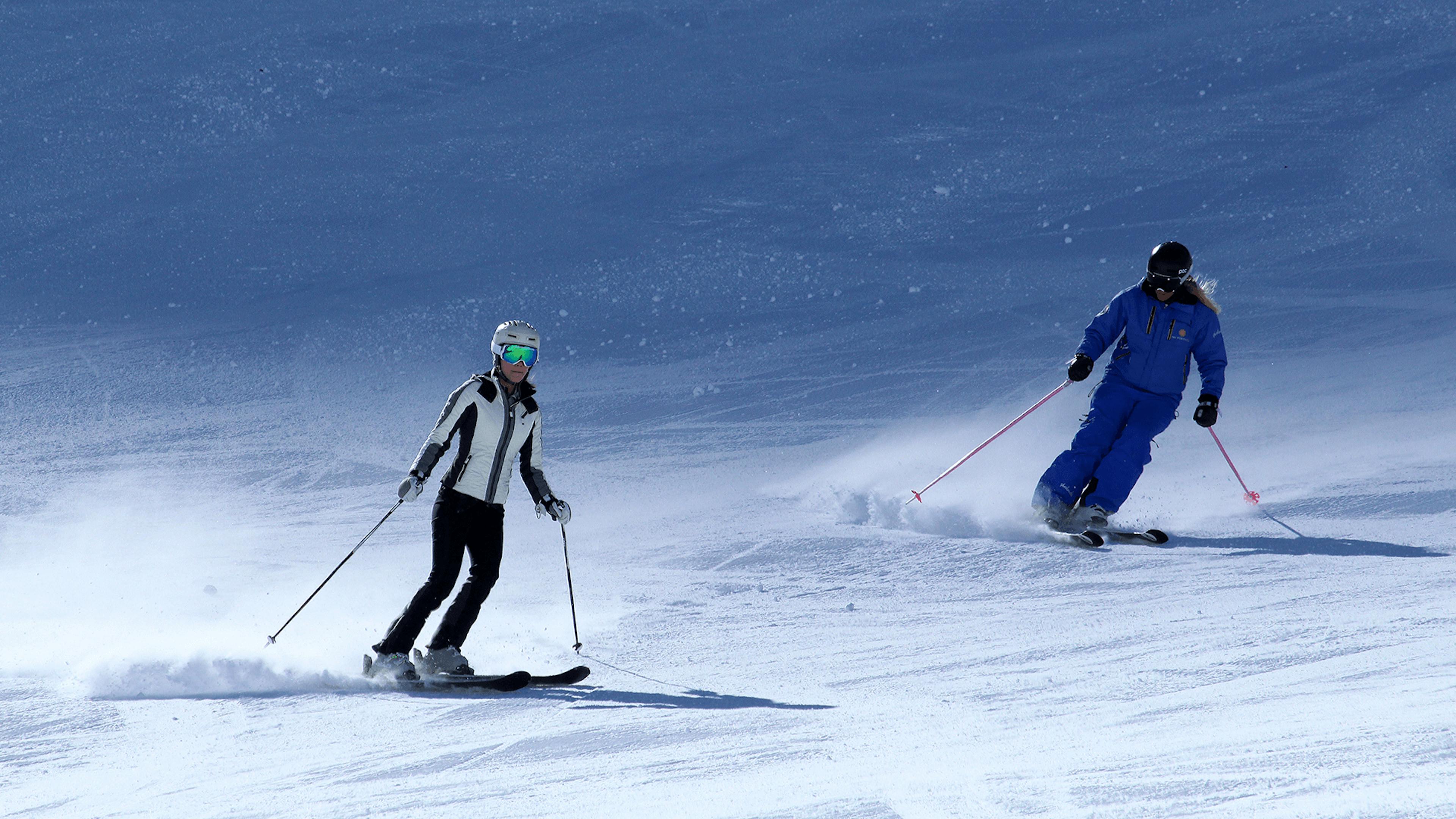 Two skiers casually skiing in Portillo in Chile, South America.