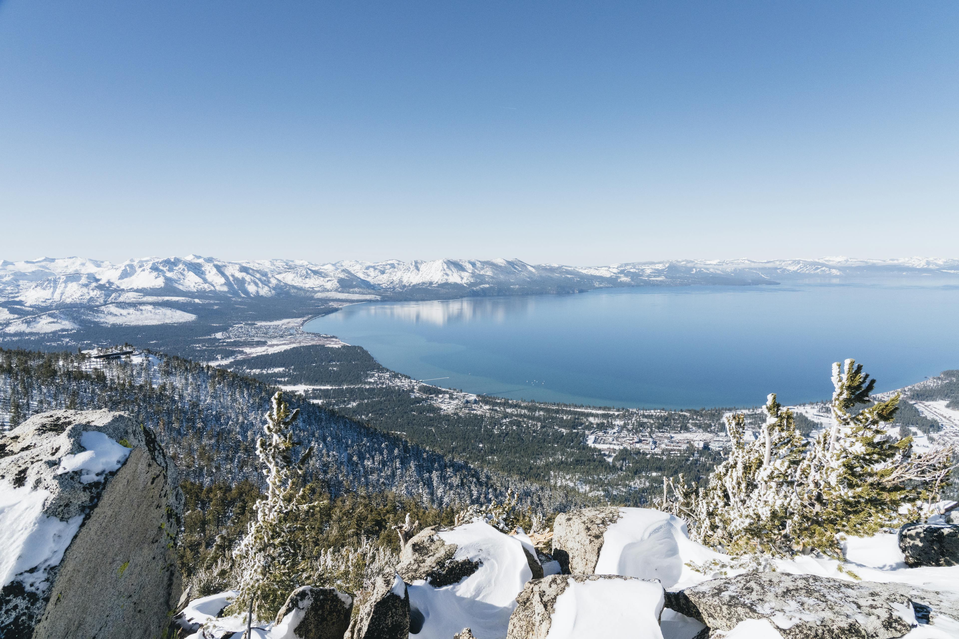 a shimmering blue lake tahoe sits in the background of heavenly ski resort ski runs