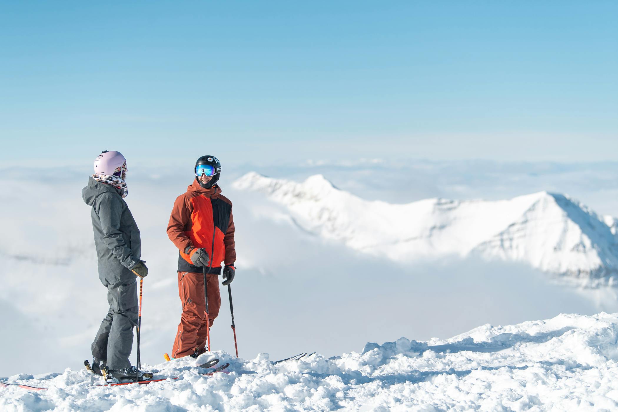 two skiers stand at the top of the slopes at Lone Peak in Big Sky in Montana, USA.