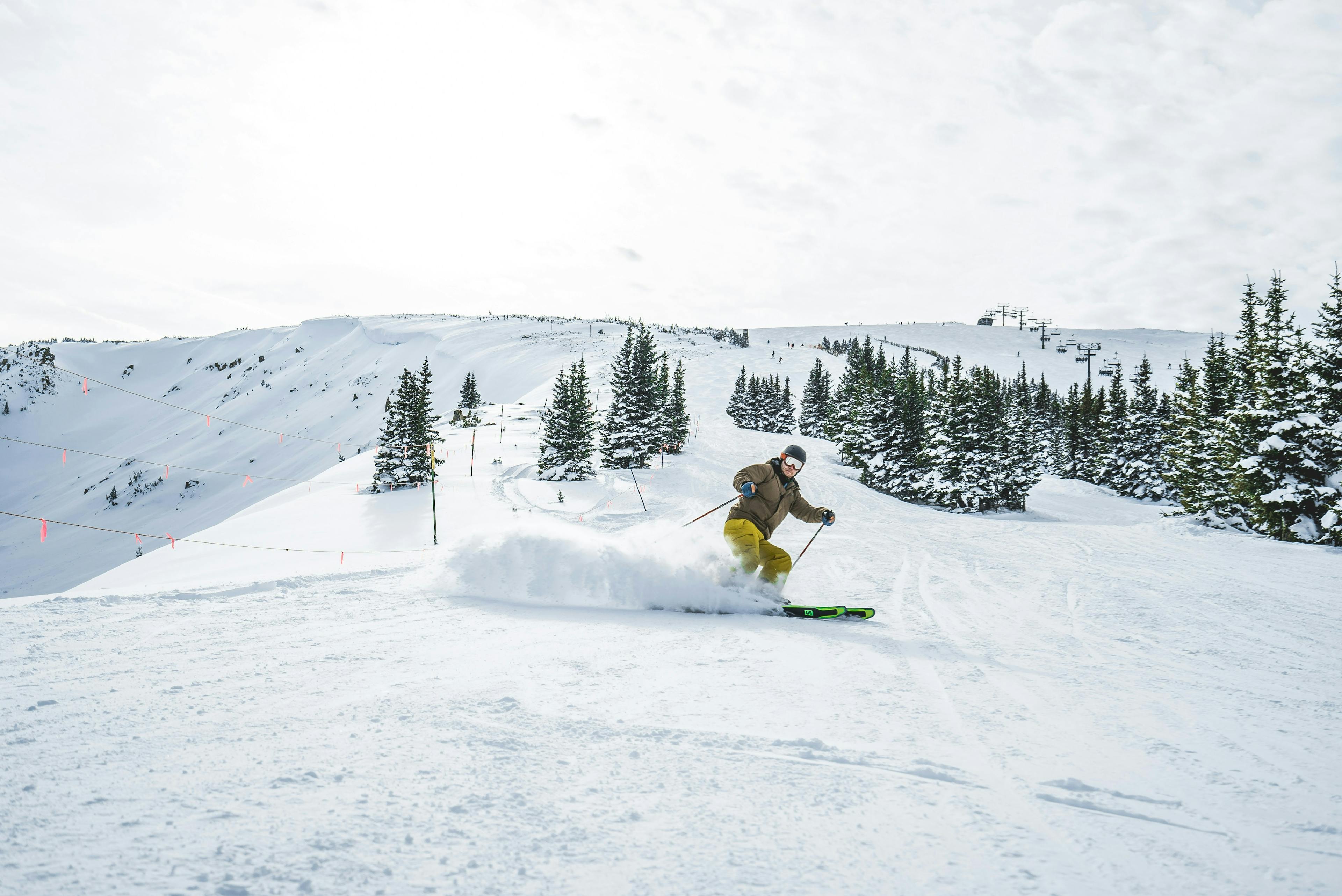 person in yellow jumpsuit skiing down the groomed slopes at Copper Mountain ski resort