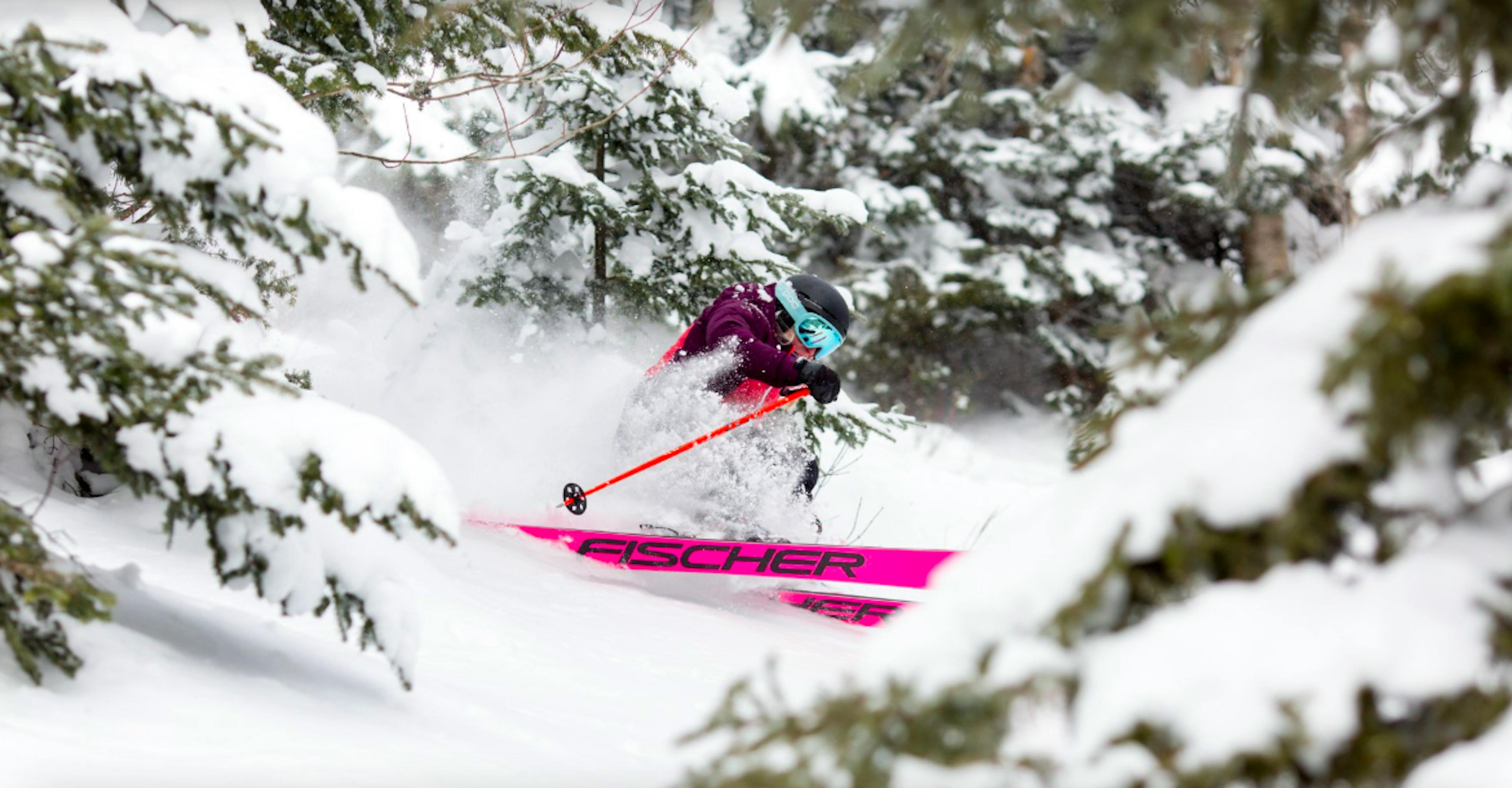 skier in a pink jumpsuit in the glades at Sugarbush ski resort