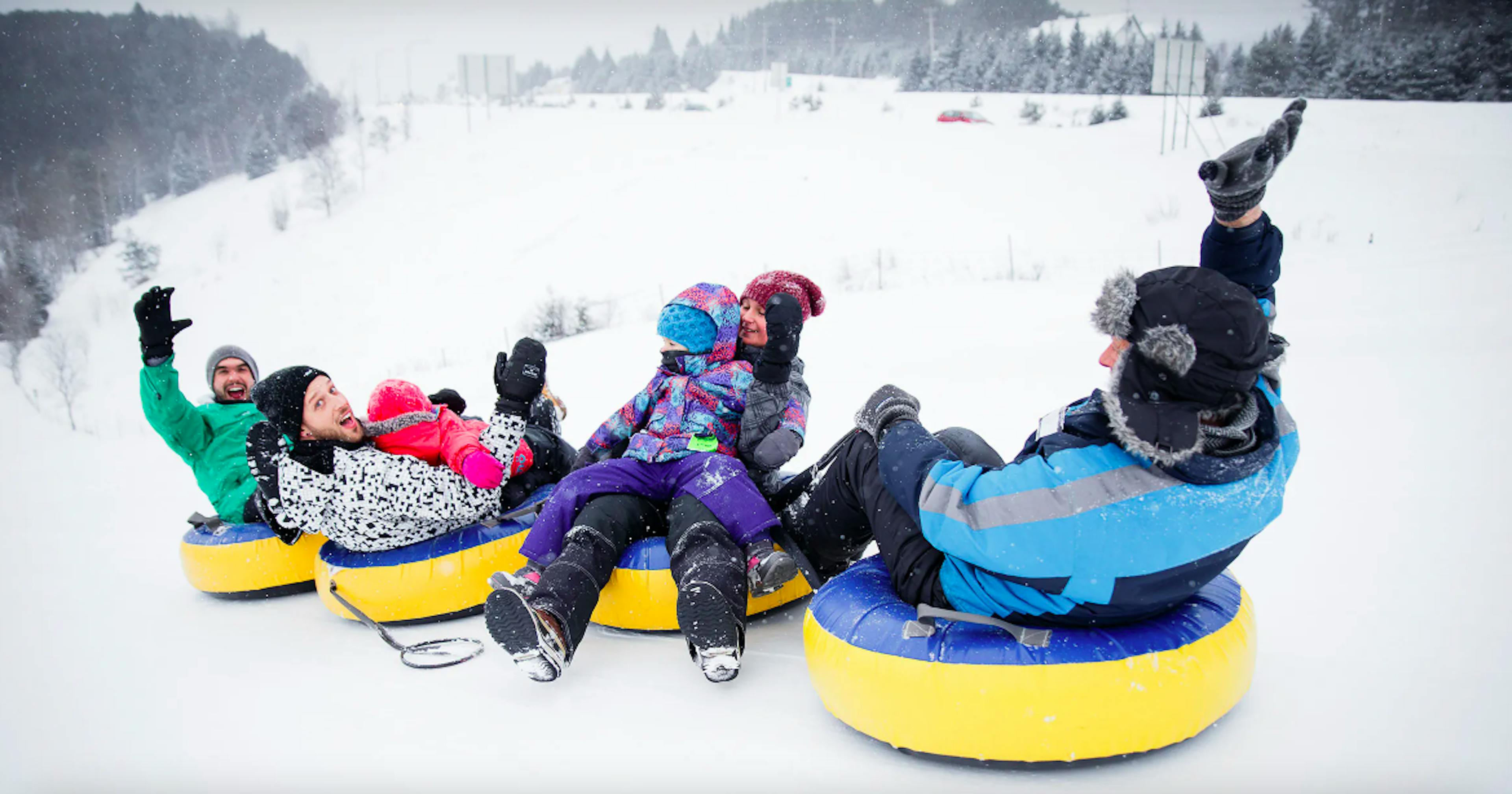 group of adults and children smiling during snow tubing at Tremblant