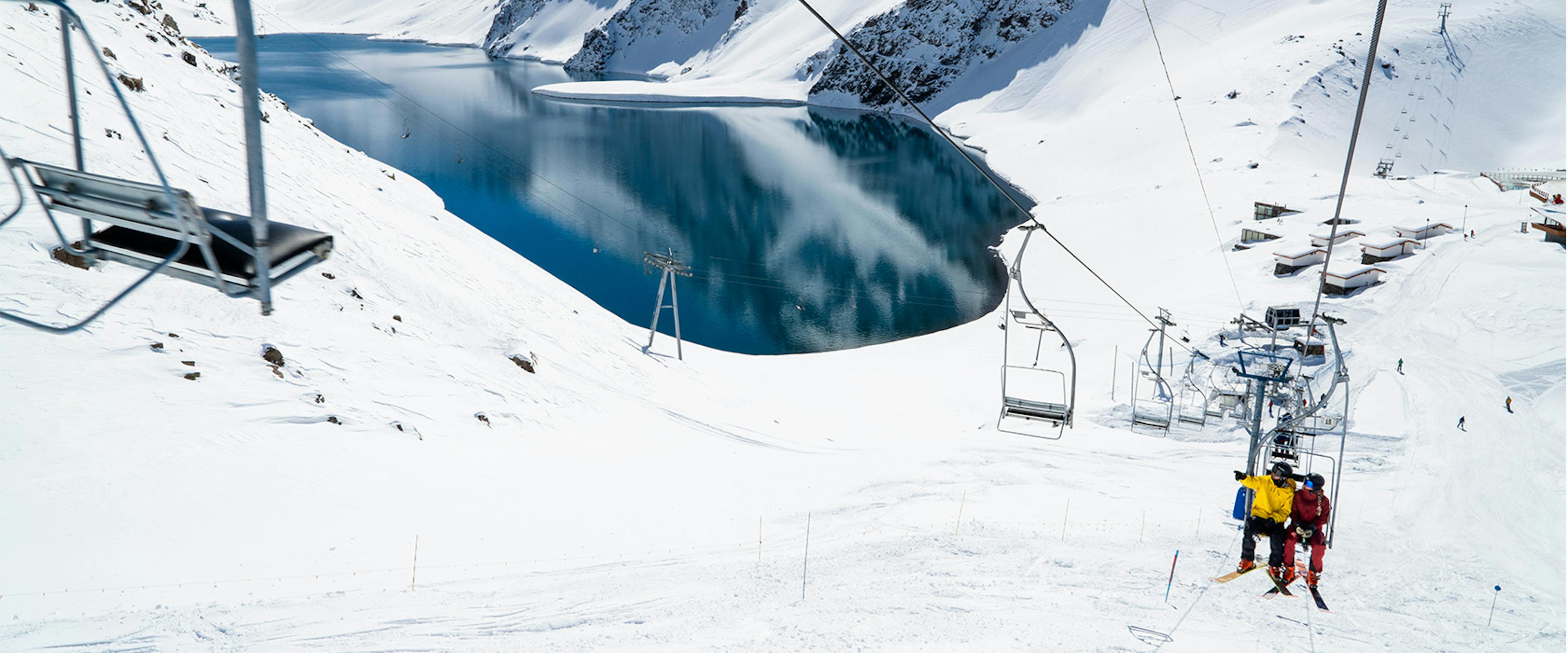 Two skiers riding the chairlift at Portillo in Chile, South America.