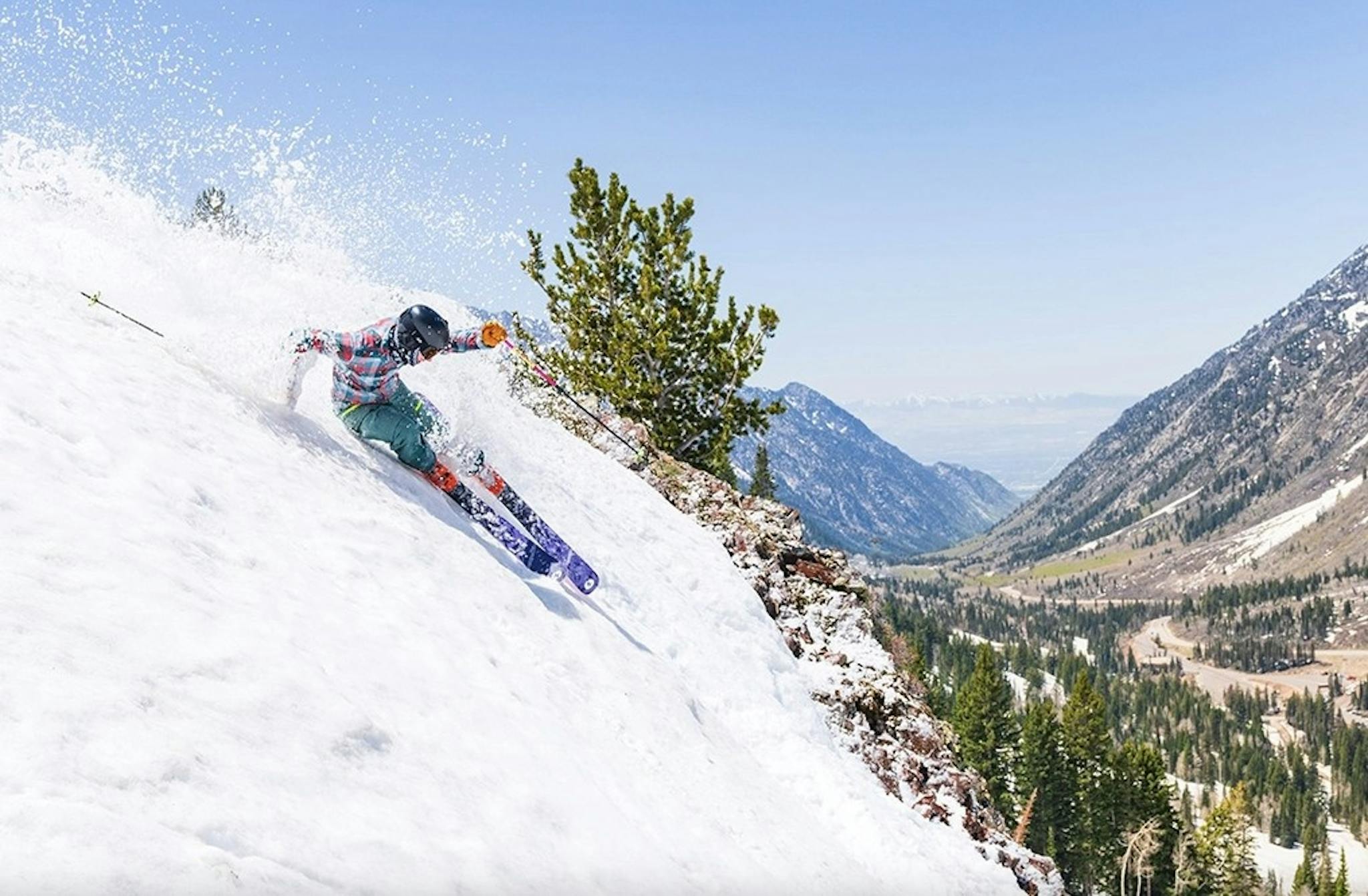 Skier shredding a steep run on a bluebird day at Snowbird Resort in Utah