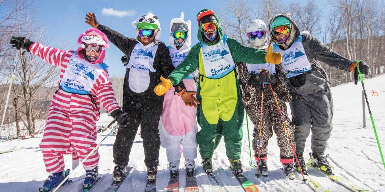 Group of skiers wearing animal onesies and racing bibs from an event at Sugarloaf Ski Resort