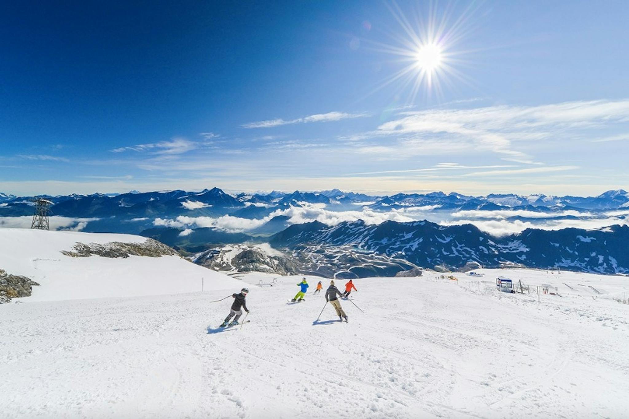 Several skiers gliding down a sunny slope in the Tignes-Val d’Isere ski area