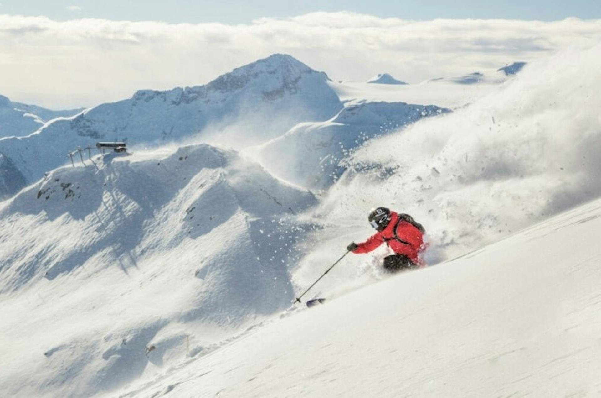 skier spraying powder at the top of a snowy mountain on Whistler Blackcomb