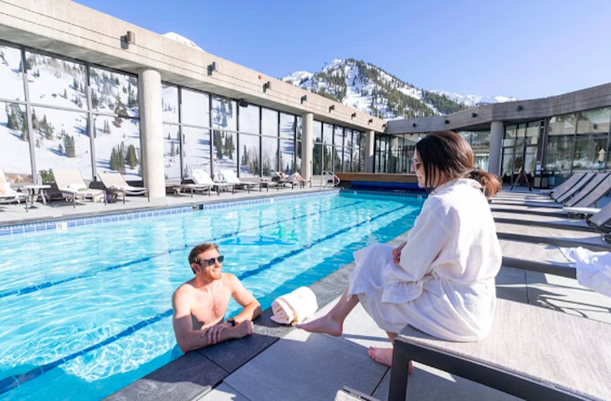 couple smiling soaking in the Cliff Spa heated rooftop pool