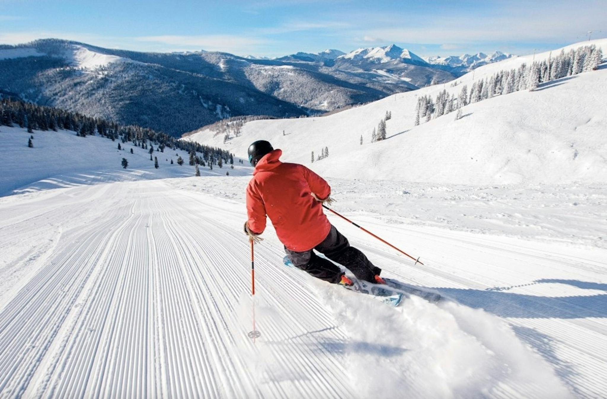 person skiing down a freshly groomed run on a sunny day at Vail