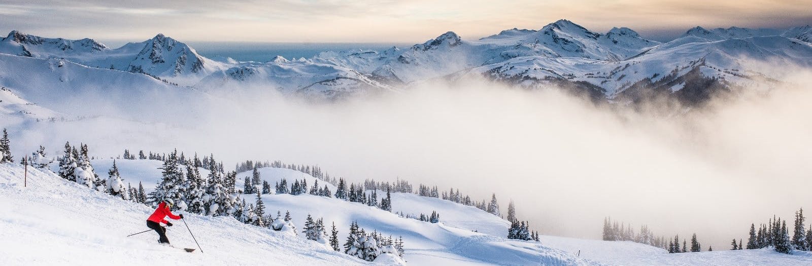 a skier in a red jacket skies above the clouds in Argentina