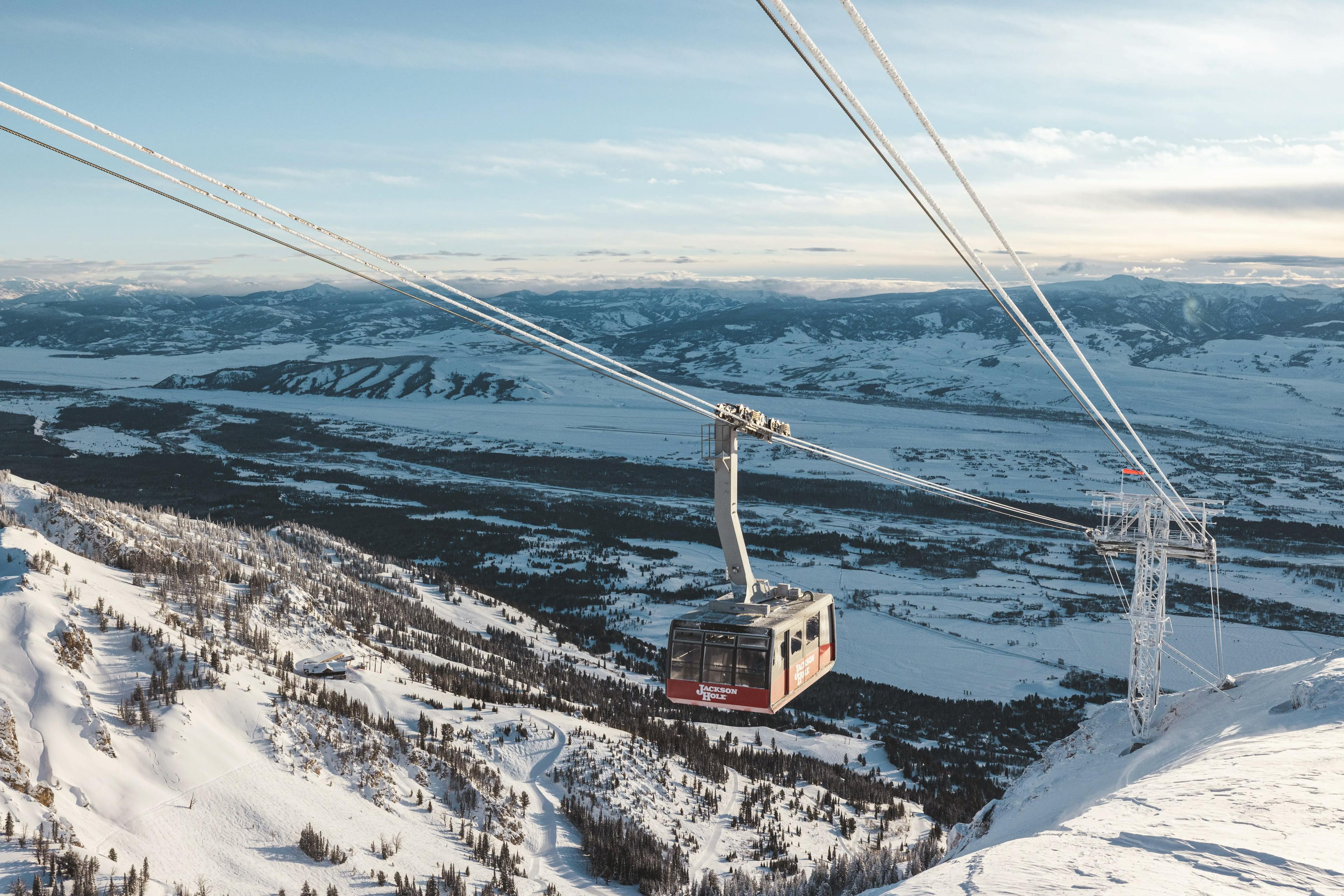 A ski lift on a snowy mountain in Jackson Hole, offering breathtaking views of the slopes and surrounding peaks.