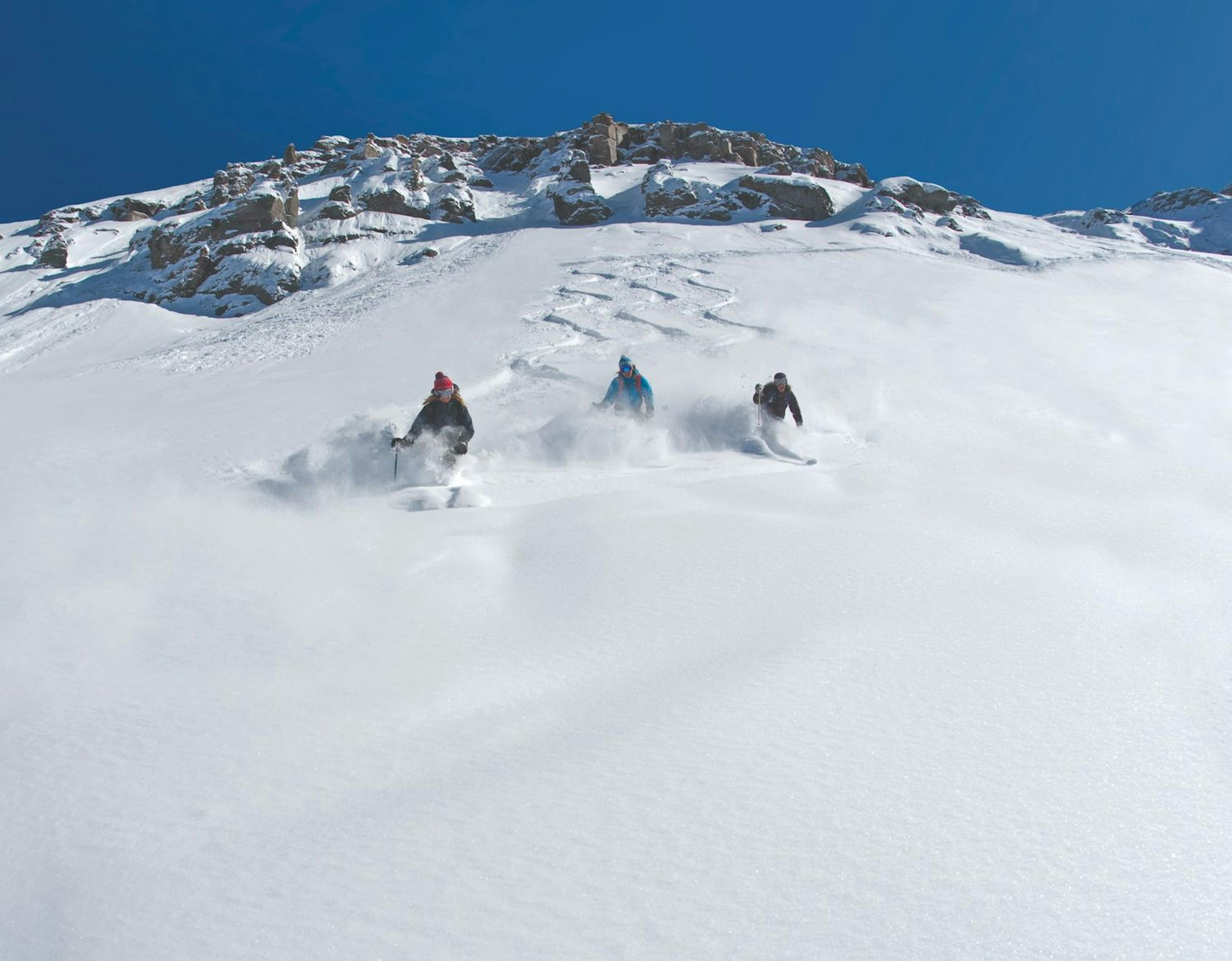 Skiers skiing in powder at Telluride Ski Resort.