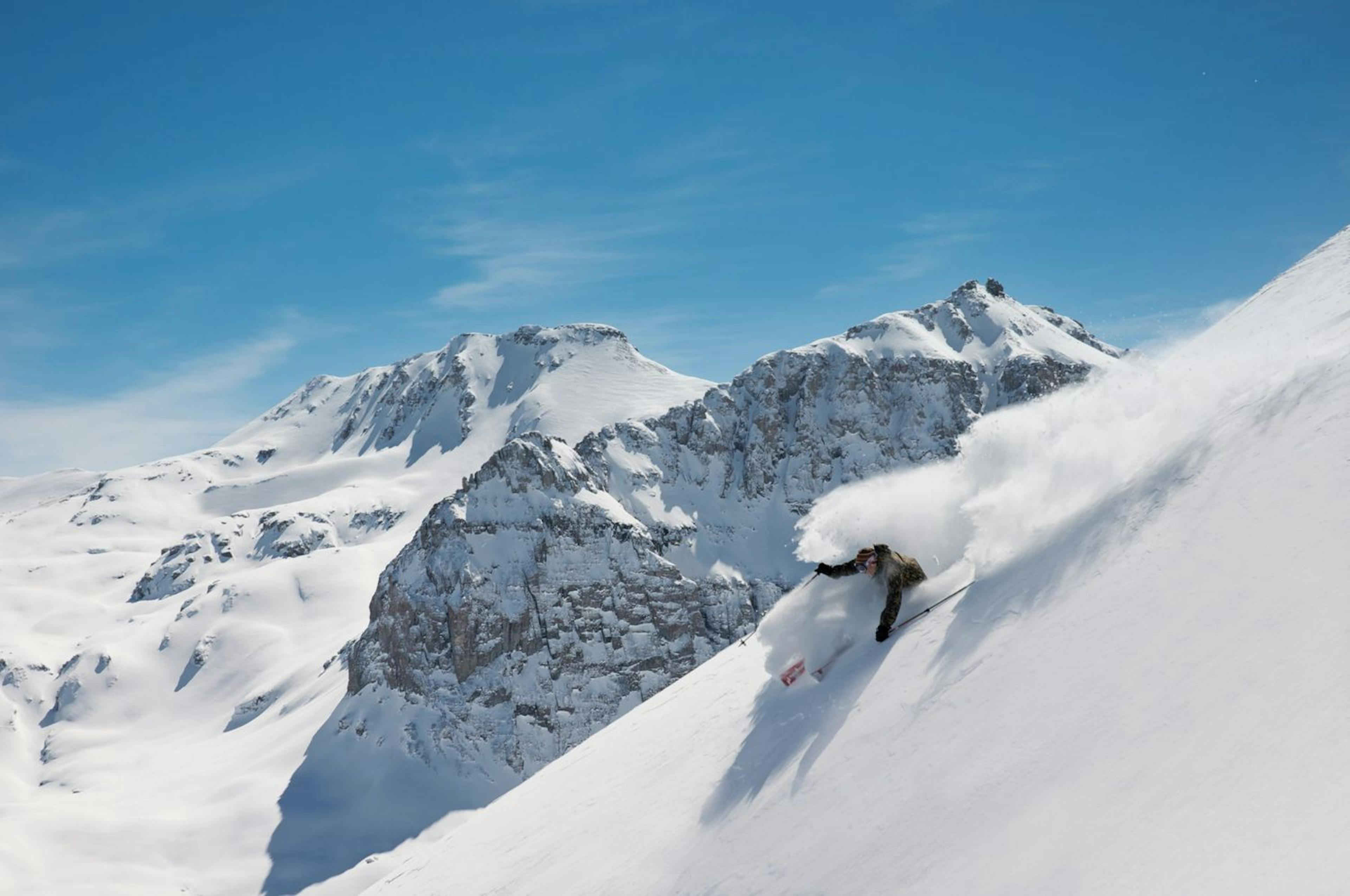 A skier skiing in powder at Telluride Ski Resort.