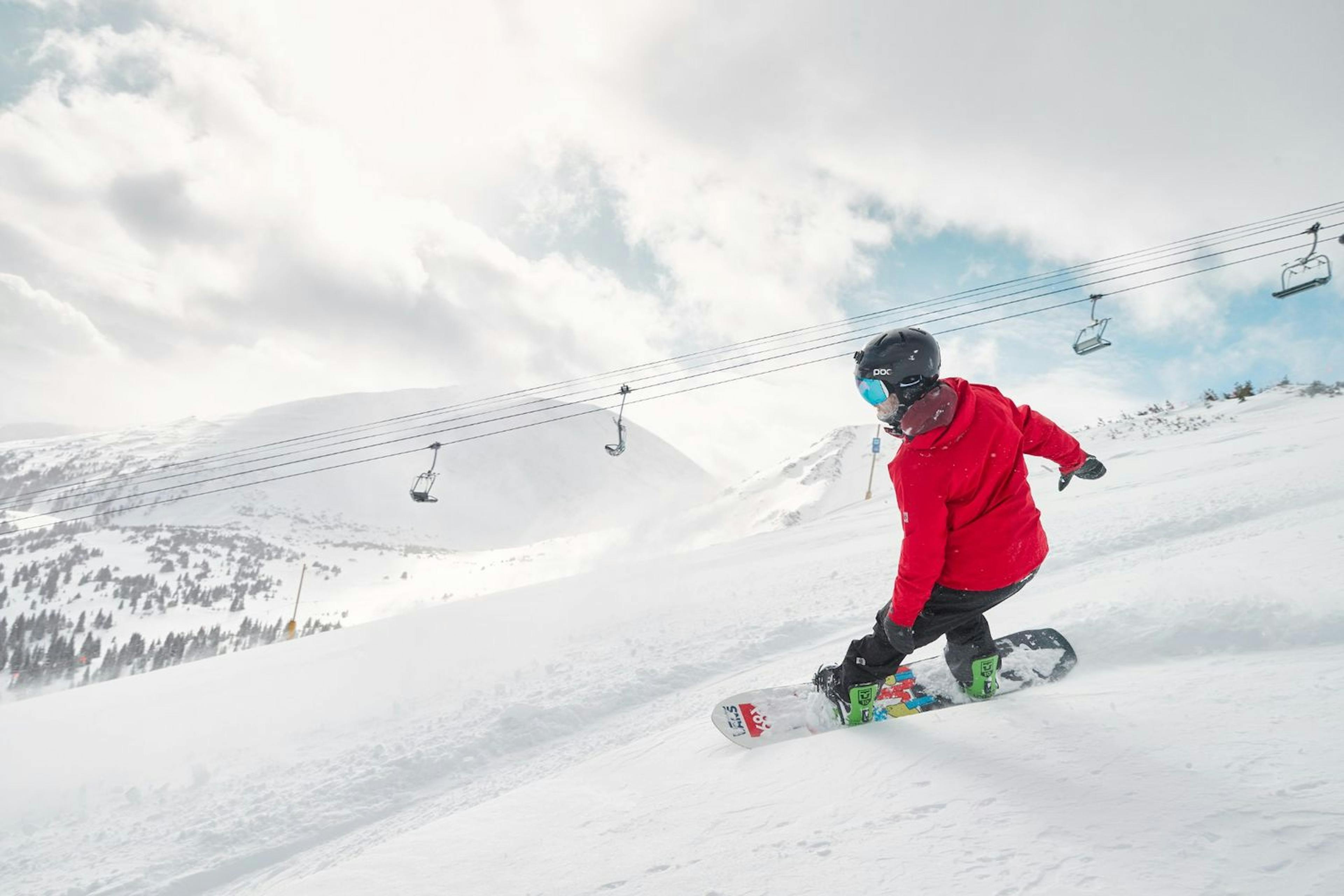 Snowboarder carving down a Breckenridge ski slope.