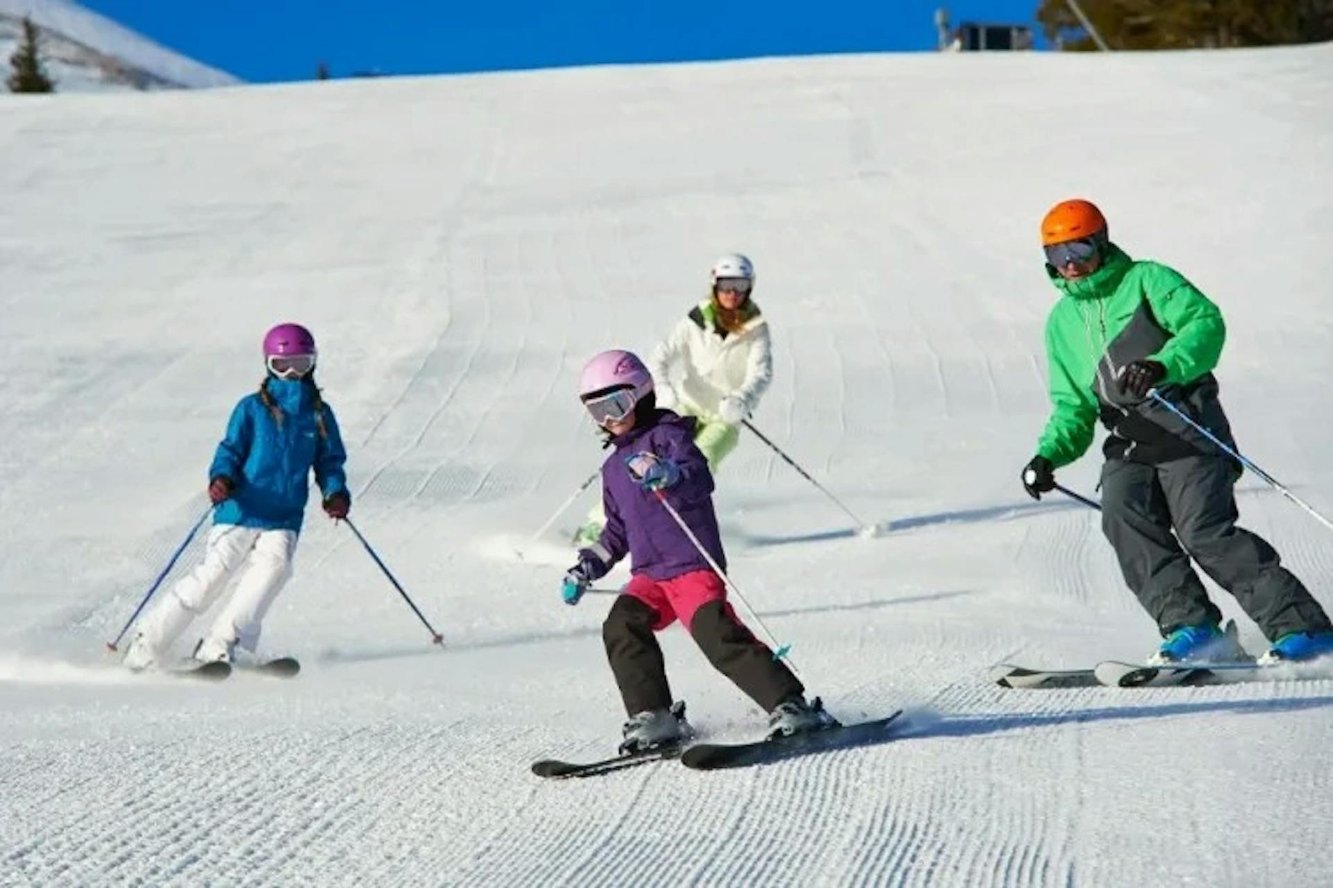 Group of skiers skiing down a groomed run at Breckenridge.