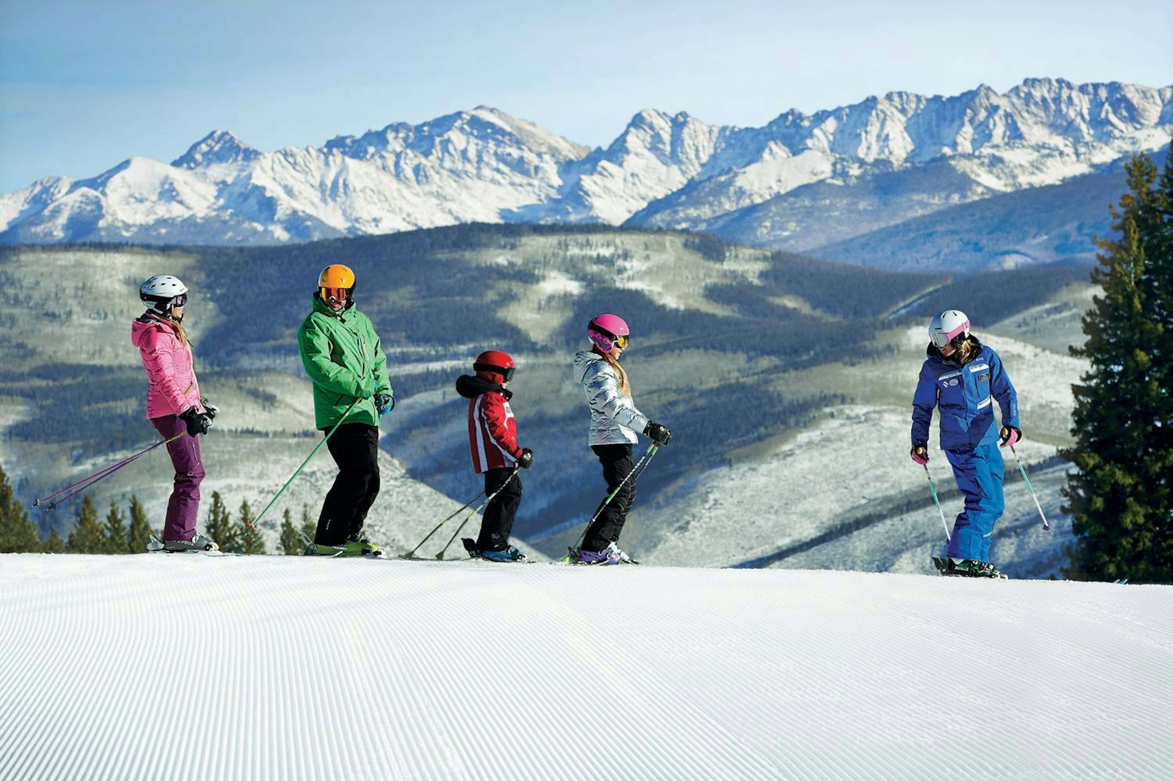 a family of skiers takes a lesson at Vail Mountain.