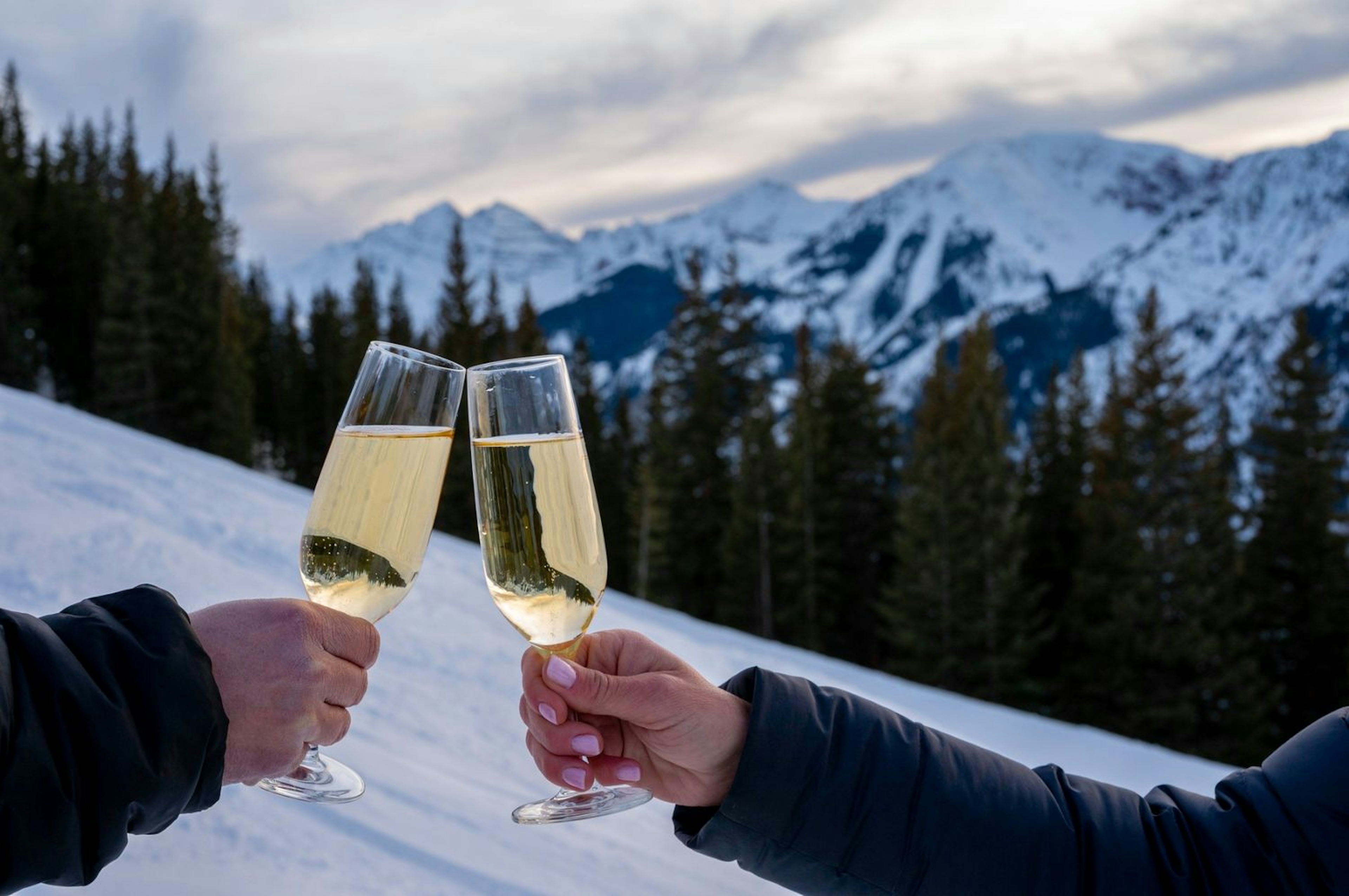 A couple drinking champagne at a luxury ski resort.