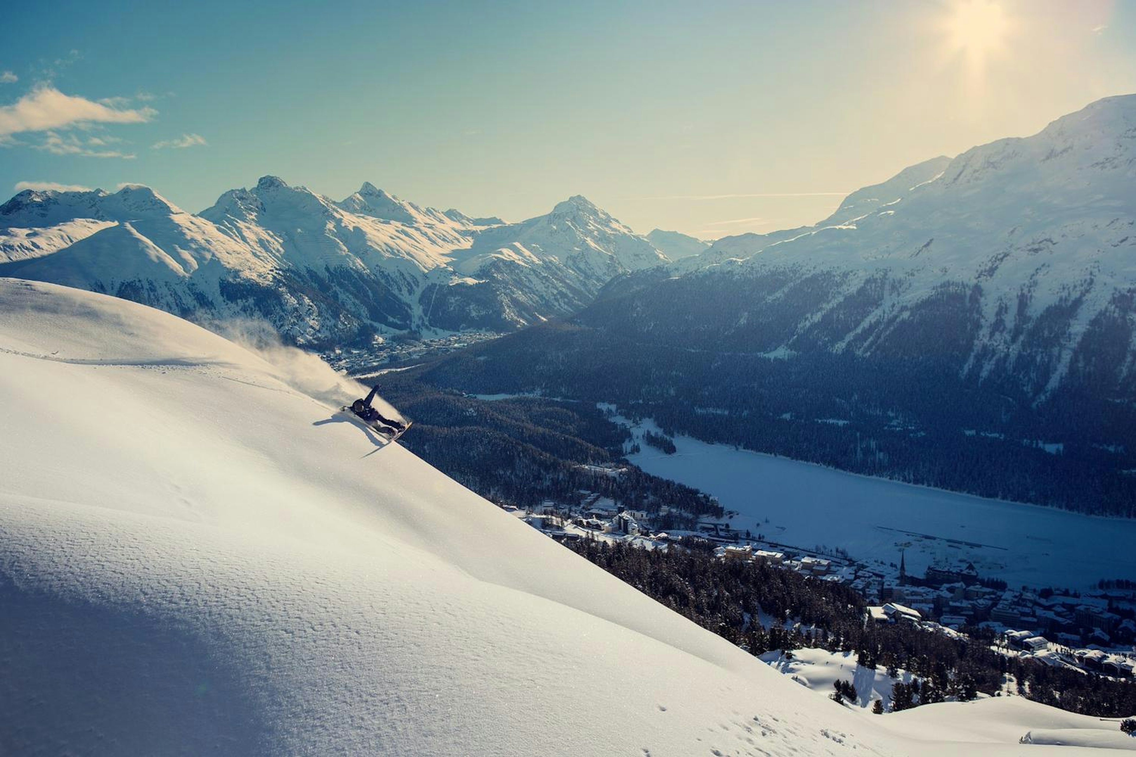 Snowboard slashes powder at St. Moritz .