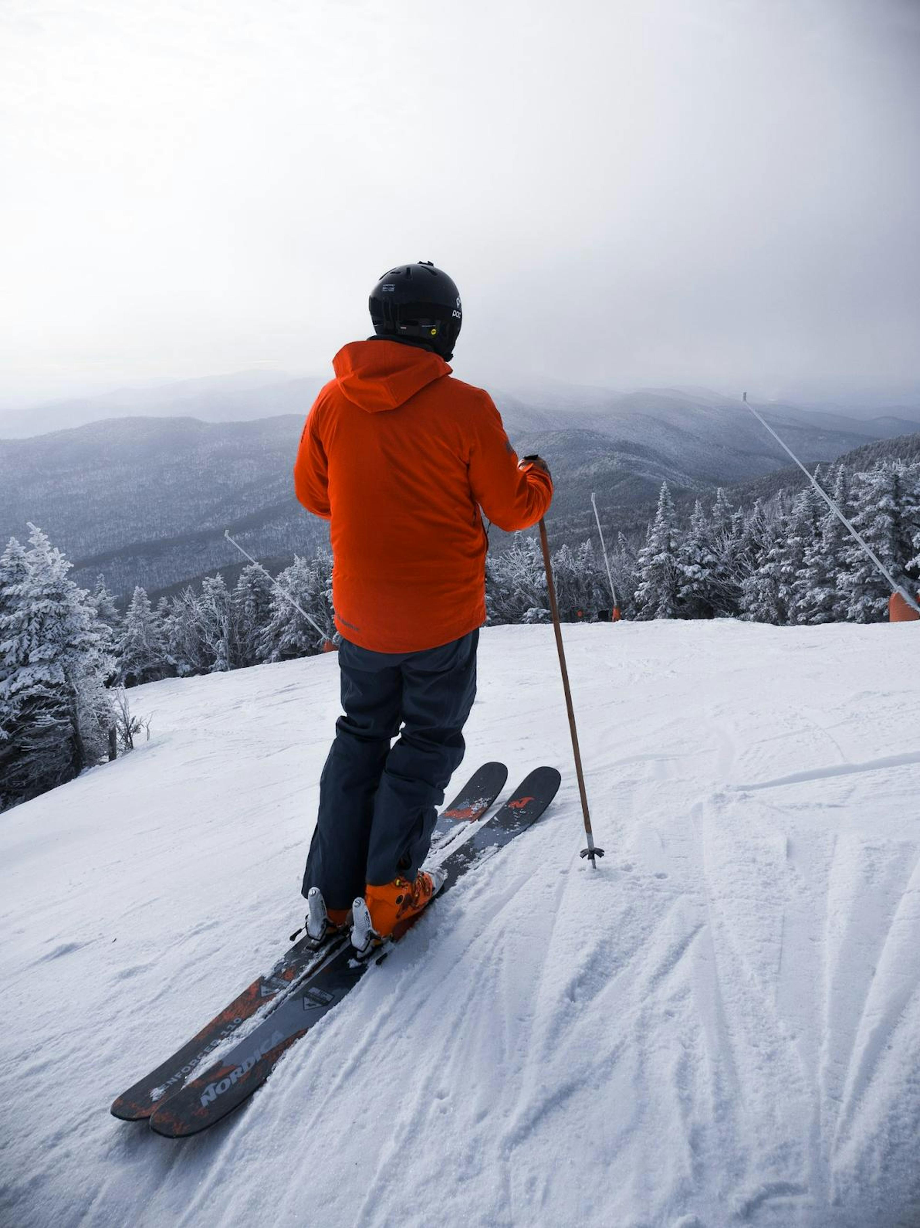 Skier in orange looking at the view at Stowe.