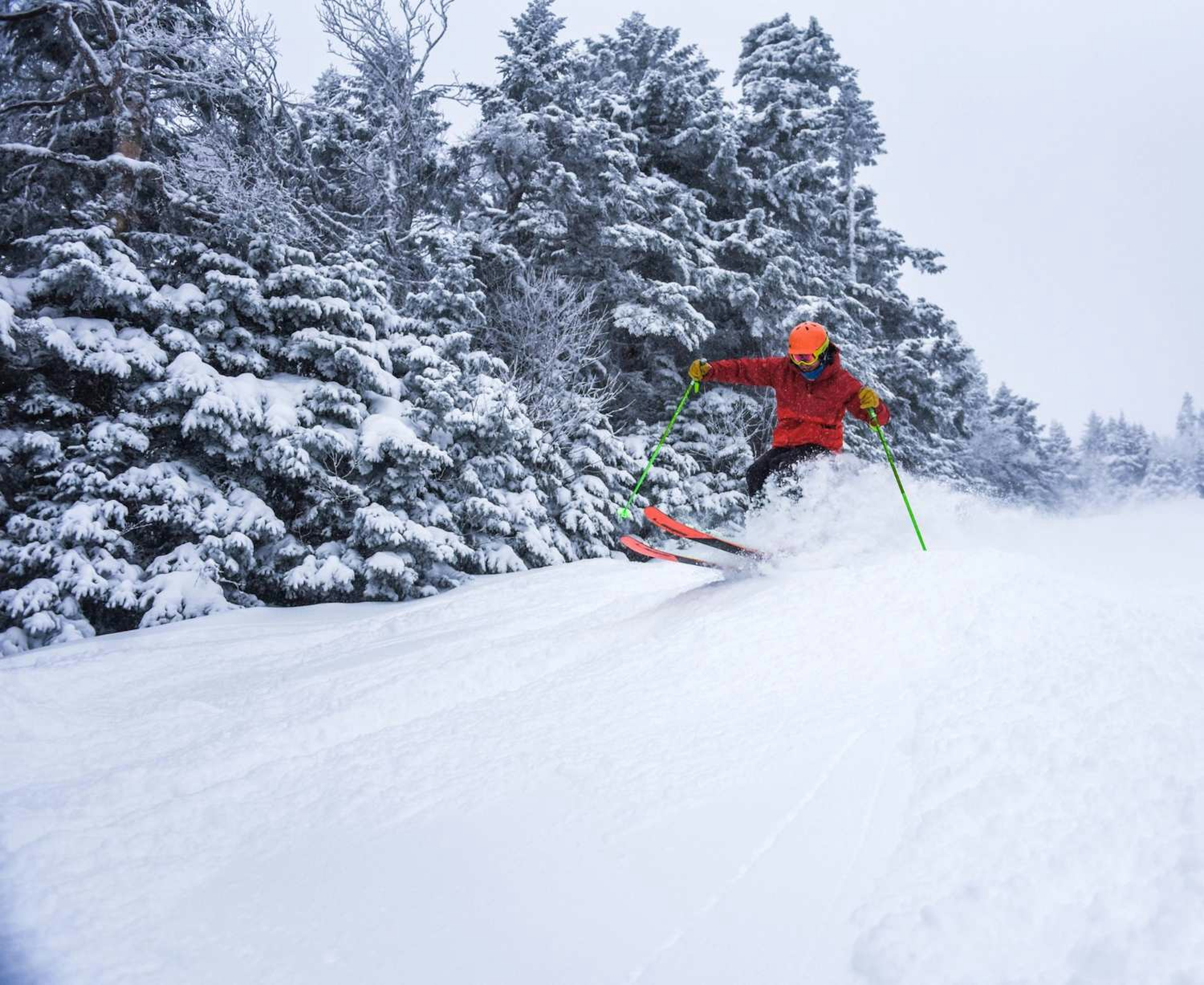 Skier in orange skiing the slopes in Sugarbush Resort