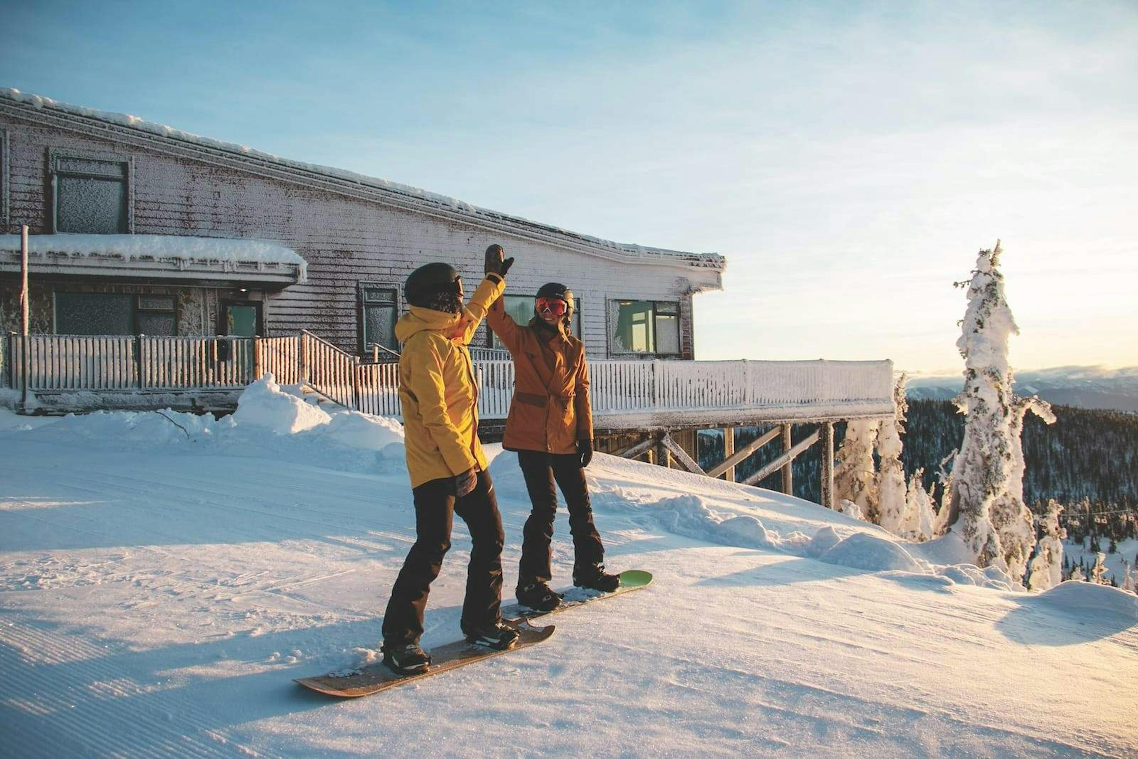 Snowboarders high-fiving at Whitefish Mountain Resort.