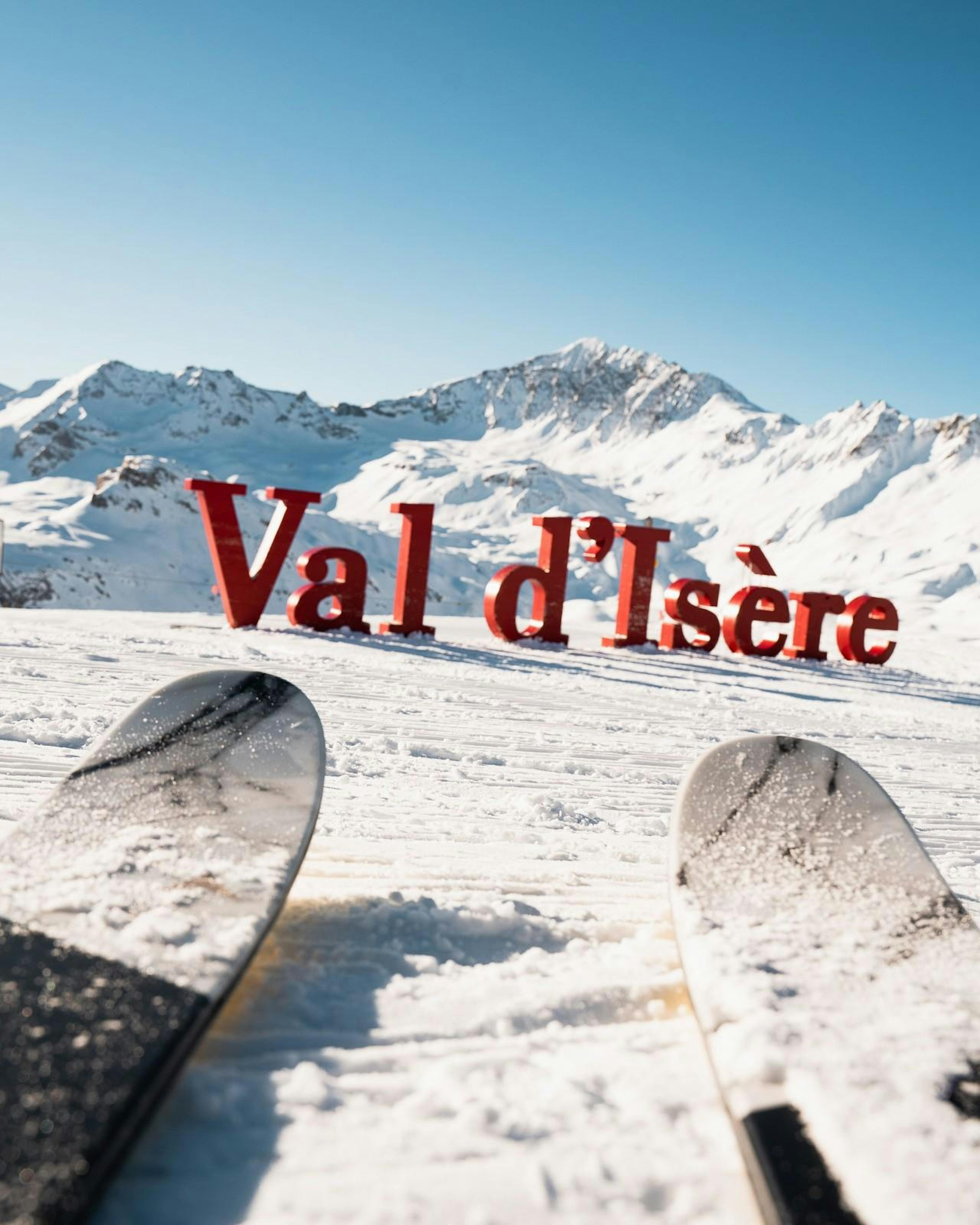 Ski tips pointing to Val d'Isère sign on slope at Val d'Isère.